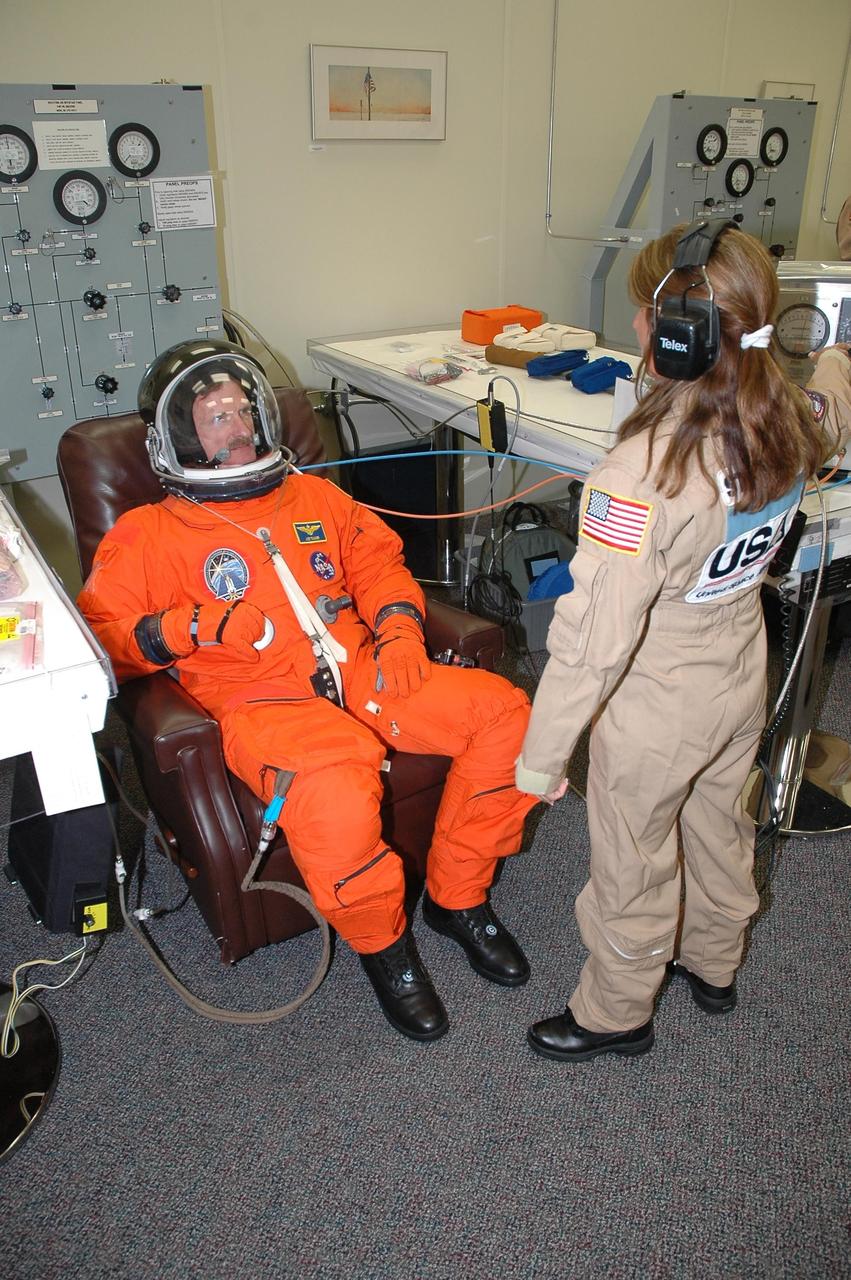 KENNEDY SPACE CENTER, FLA. - The STS-115 crew members are checking the fit of their launch and entry suits before tomorrow's simulated launch countdown. In the chair is Mission Specialist Joseph Tanner. The simulation is the culmination of Terminal Countdown Demonstration Test activities at NASA's Kennedy Space Center. The crew is getting ready for their launch on Space Shuttle Atlantis, scheduled to take place in a window that opens Aug. 27. During the 11-day mission to the International Space Station, the STS-115 crew will continue construction of the station and install their cargo, the Port 3/4 truss segment with its two large solar arrays. Photo credit: NASA/Cory Huston