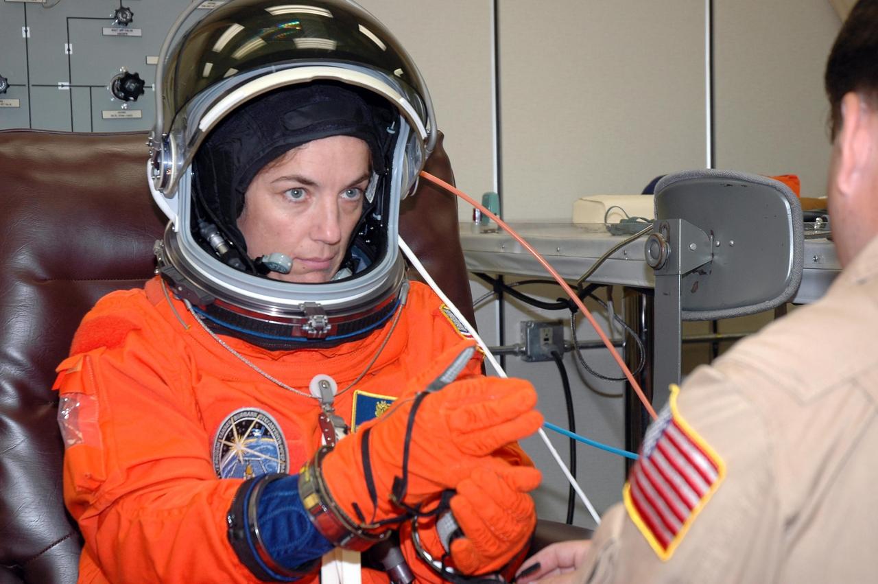 KENNEDY SPACE CENTER, FLA. - The STS-115 crew members are checking the fit of their launch and entry suits before tomorrow's simulated launch countdown. Checking her glove is Mission Specialist Heidemarie Stefanyshyn-Piper. The simulation is the culmination of Terminal Countdown Demonstration Test activities at NASA's Kennedy Space Center. The crew is getting ready for their launch on Space Shuttle Atlantis, scheduled to take place in a window that opens Aug. 27. During the 11-day mission to the International Space Station, the STS-115 crew will continue construction of the station and install their cargo, the Port 3/4 truss segment with its two large solar arrays. Photo credit: NASA/Cory Huston