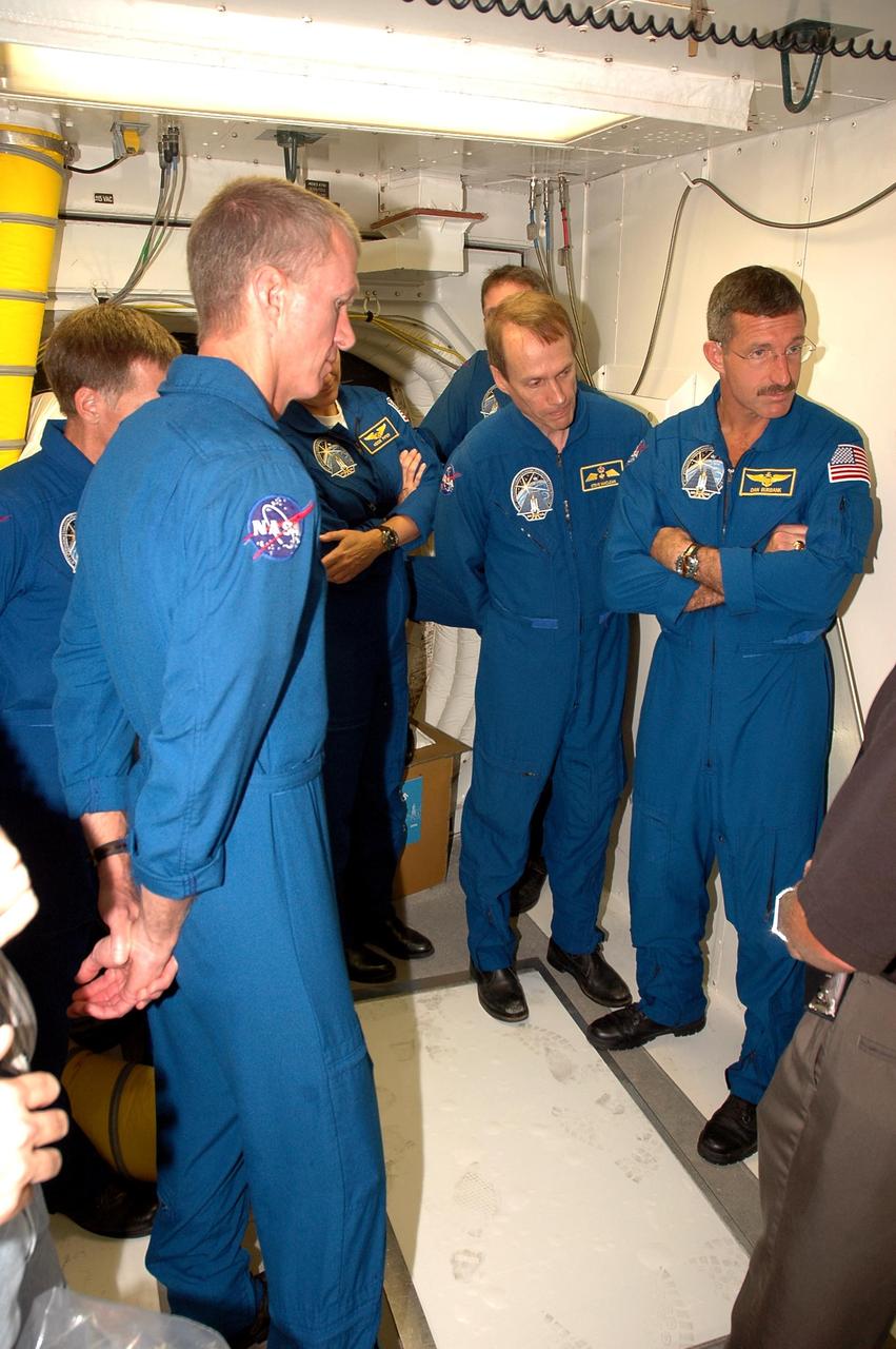 KENNEDY SPACE CENTER, FLA. - The STS-115 crew is in the White Room on the orbiter access arm on Launch Pad 39B to get instruction on using the emergency egress system. From left are Commander Brent Jett, Pilot Chris Ferguson, and Mission Specialists Heidemarie Stefanyshyn-Piper, Joseph Tanner, Steven MacLean and Daniel Burbank. MacLean is with the Canadian Space Agency. he White Room provides access into the orbiter through the crew access hatch. The mission crew is at KSC for Terminal Countdown Demonstration Test (TCDT) activities that are preparation for launch on Space Shuttle Atlantis, scheduled to take place in a window that opens Aug. 27. During their 11-day mission to the International Space Station, the STS-115 crew will continue construction of the station and attach the payload elements, the Port 3/4 truss segment with its two large solar arrays. Photo credit: NASA/Cory Huston