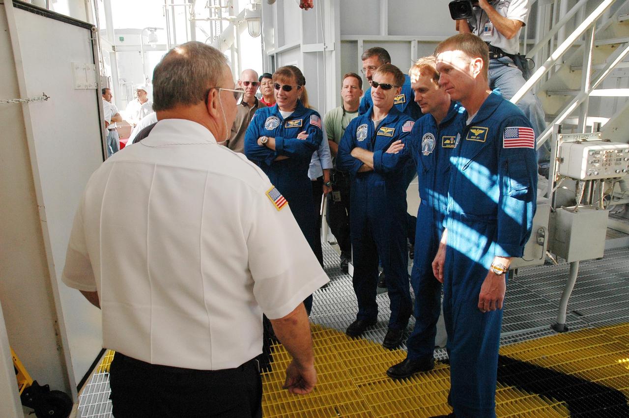 KENNEDY SPACE CENTER, FLA. - The STS-115 crew gets instructions about using the slidewire baskets for emergency egress from the space shuttle on the pad. Seen here are Mission Specialists Heidemarie Stefanyshyn-Piper and Daniel Burbank, Pilot Chris Ferguson, Mission Specialist Steven MacLean and Commander Brent Jett. MacLean is with the Canadian Space Agency. Not seen is Mission Specialist Joseph Tanner. The mission crew is at KSC for Terminal Countdown Demonstration Test (TCDT) activities that are preparation for launch on Space Shuttle Atlantis, scheduled to take place in a window that opens Aug. 27. During their 11-day mission to the International Space Station, the STS-115 crew will continue construction of the station and attach the payload elements, the Port 3/4 truss segment with its two large solar arrays. Photo credit: NASA/Cory Huston