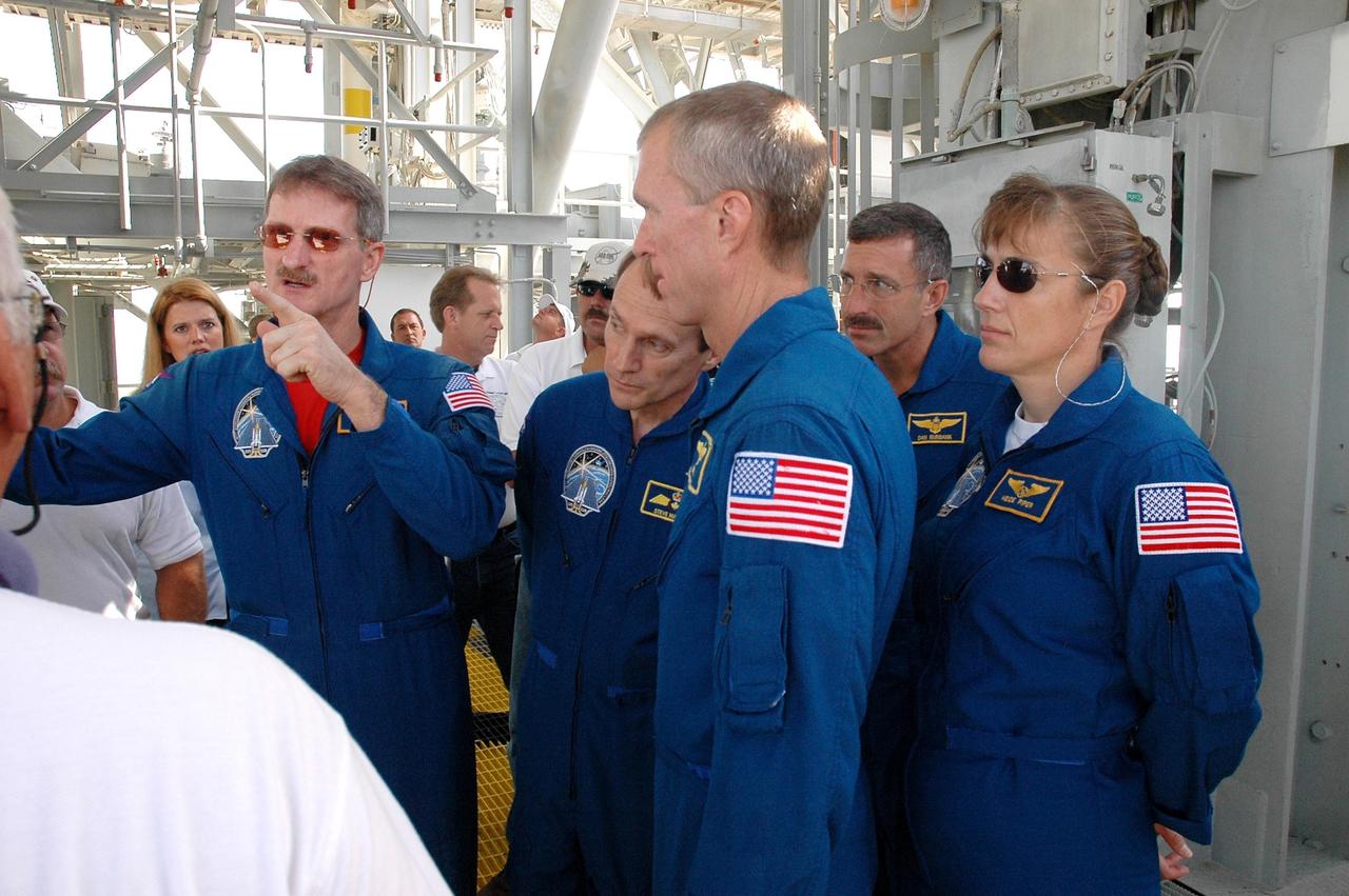 KENNEDY SPACE CENTER, FLA. - The STS-115 crew gets instructions about using the slidewire baskets for emergency egress from the space shuttle on the pad. At center, foreground, is Commander Brent Jett. The others, from left are Mission Specialists Joseph Tanner, gesturing, Steven MacLean, Daniel Burbank and Heidemarie Stefanyshyn-Piper. MacLean is with the Canadian Space Agency. The mission crew is at KSC for Terminal Countdown Demonstration Test (TCDT) activities that are preparation for launch on Space Shuttle Atlantis, scheduled to take place in a window that opens Aug. 27. During their 11-day mission to the International Space Station, the STS-115 crew will continue construction of the station and attach the payload elements, the Port 3/4 truss segment with its two large solar arrays. Photo credit: NASA/Cory Huston