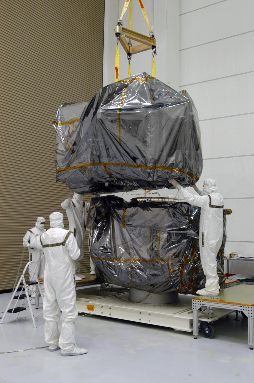 KENNEDY SPACE CENTER, FLA. - At Astrotech Space Operations in Titusville, Fla., workers guide one of the STEREO observatories as it is lowered toward the other observatory. They will be mated for launch. STEREO, which stands for Solar Terrestrial Relations Observatory, is the first to take measurements of the sun and solar wind in 3-dimension. This new view will improve our understanding of space weather and its impact on the Earth. STEREO is expected to lift off aboard a Boeing Delta II rocket from Launch Pad 17-B at Cape Canaveral Air Force Station on Aug. 31. Photo credit: NASA/George Shelton