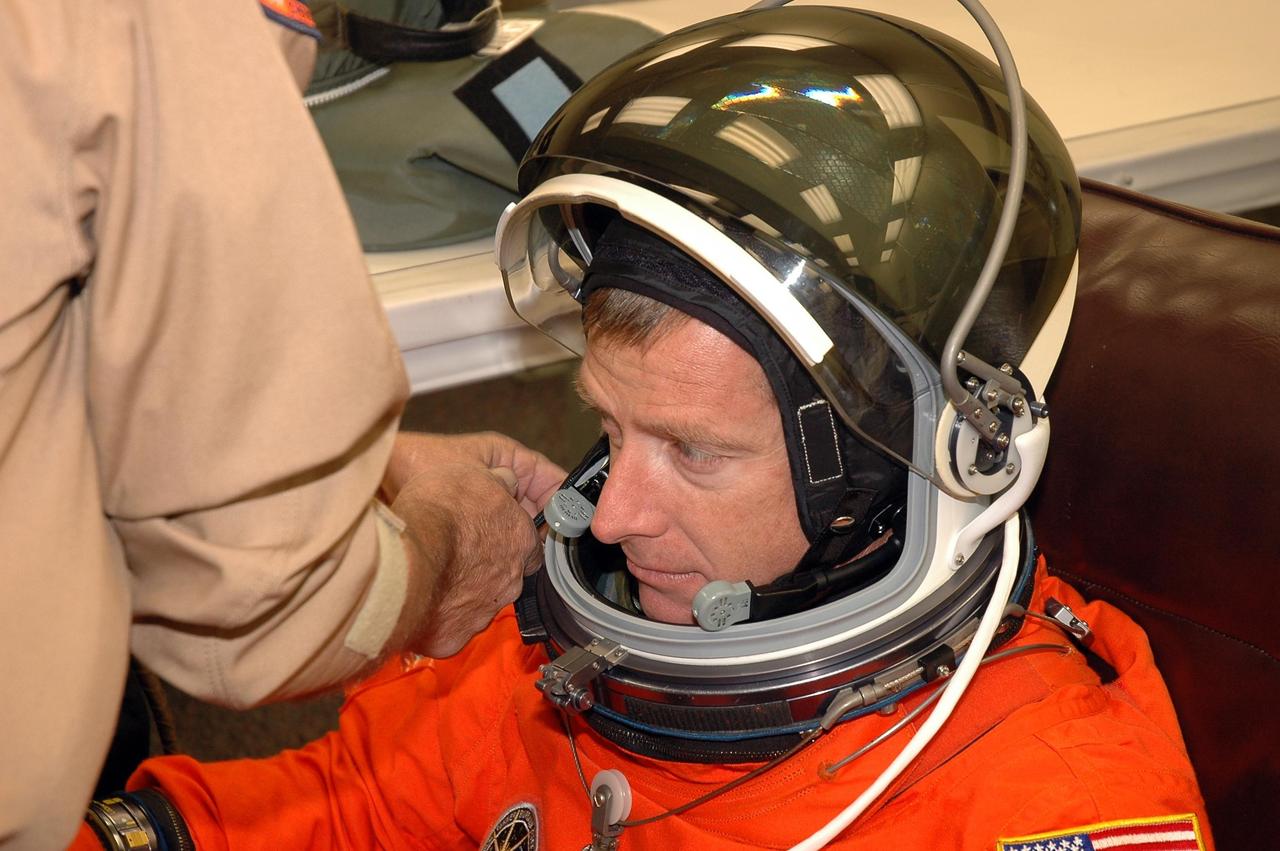 KENNEDY SPACE CENTER, FLA. -   The STS-115 crew members are suiting up for their simulated launch countdown.  Shown here being helped with his helmet is Pilot Christopher Ferguson. The mission crew is at KSC for Terminal Countdown Demonstration Test (TCDT) activities that are preparation for launch on Space Shuttle Atlantis, scheduled to take place in a window that opens Aug. 27.  The TCDT has included emergency egress training as well as the simulation.  During their 11-day mission to the International Space Station, the STS-115 crew will continue construction of the station and attach the payload elements, the Port 3/4 truss segment with its two large solar arrays.  Photo credit: NASA/Cory Huston