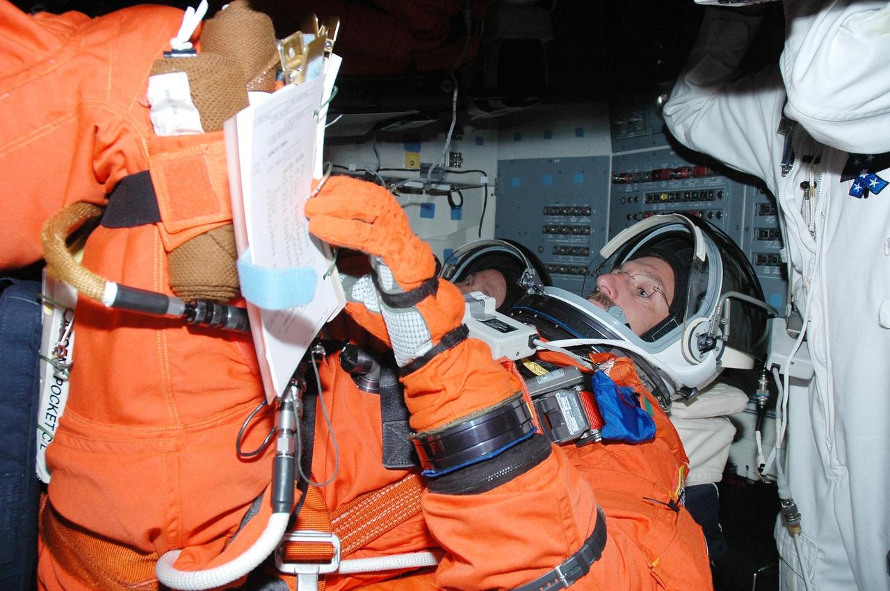 KENNEDY SPACE CENTER, FLA. -   Inside Atlantis' cockpit, STS-115 Mission Specialists Daniel Burbank (front) and Steven MacLean, are taking part in a simulated launch countdown, the culmination of Terminal Countdown Demonstration Test activities.   The TCDT is a prelaunch preparation for the mission that is scheduled to lift off in a window opening Aug. 27. During their 11-day mission to the International Space Station, the STS-115 crew will continue construction of the station and attach the payload elements, the Port 3/4 truss segment with its two large solar arrays.