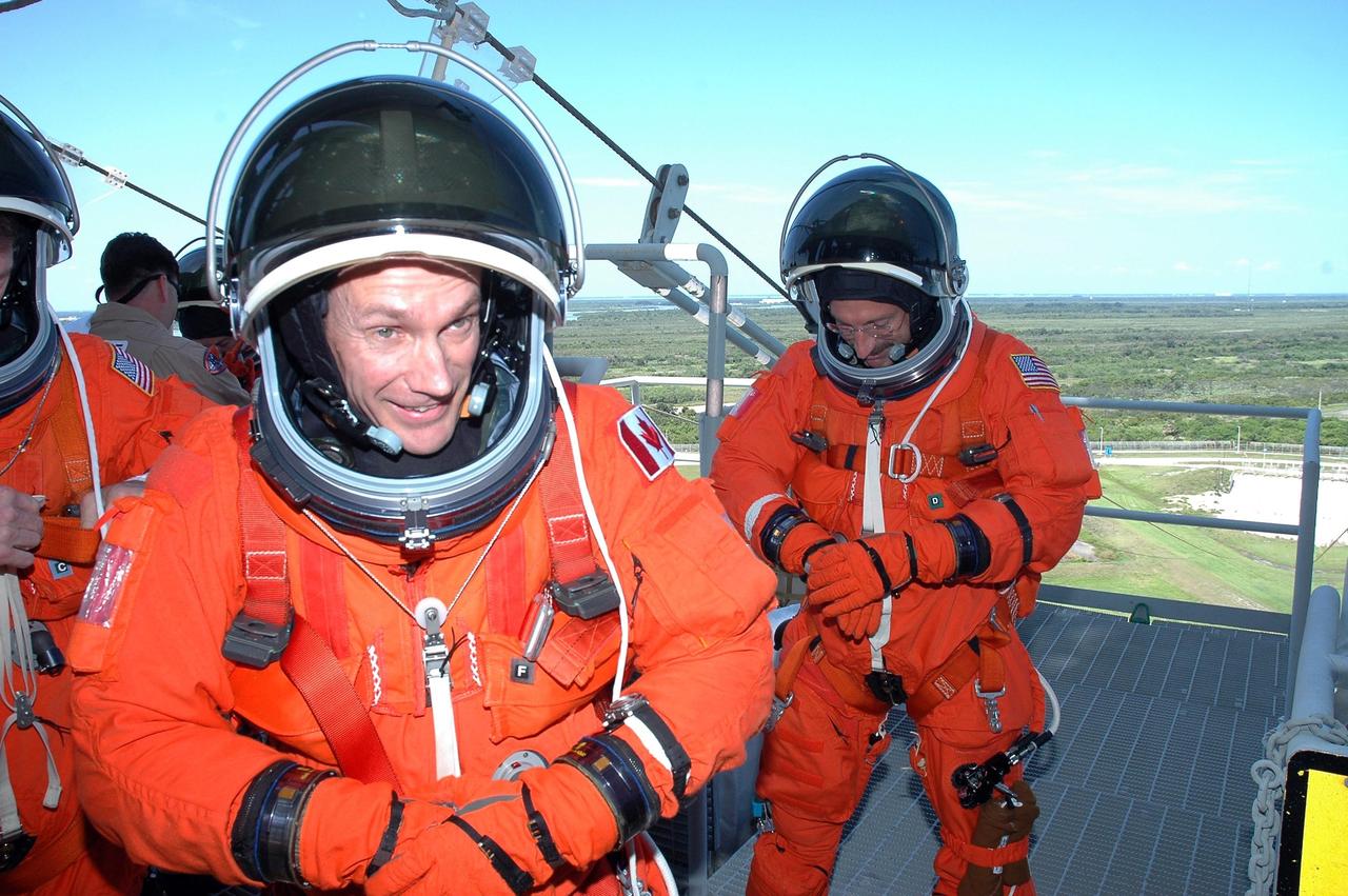 KENNEDY SPACE CENTER, FLA. - The STS-115 crew members conclude their emergency egress procedures on Launch Pad 39B. In the foreground is Mission Specialist Steven MacLean, who is with the Canadian Space Agency. At right is Mission Specialist Joseph Tanner. At far left is Mission Specialist Heidemarie Stefanyshyn-Piper. The TCDT is a prelaunch preparation for the mission that is scheduled to lift off in a window opening Aug. 27. During their 11-day mission to the International Space Station, the STS-115 crew will continue construction of the station and attach the payload elements, the Port 3/4 truss segment with its two large solar arrays. Photo credit: NASA/Cory Huston