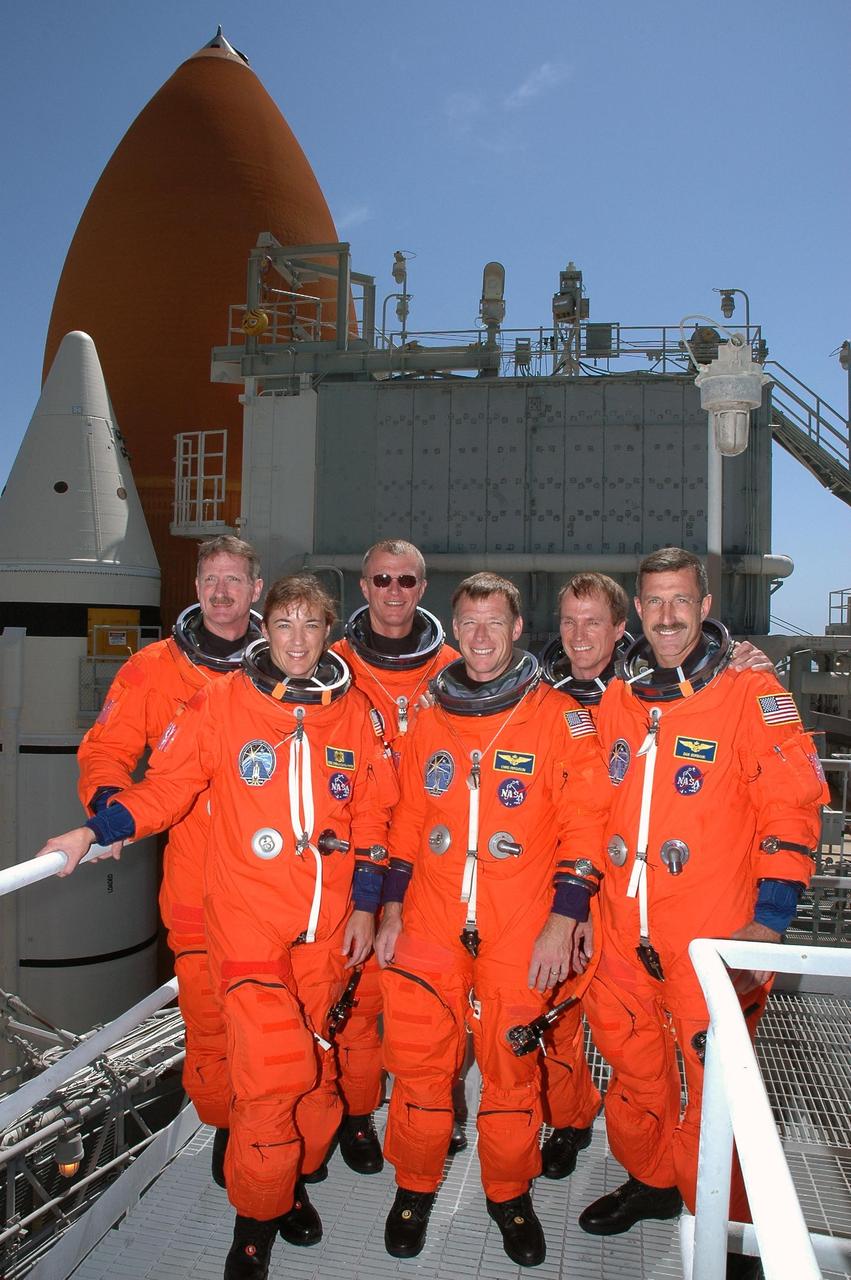 KENNEDY SPACE CENTER, FLA. -   Following a simulated launch countdown and emergency egress practice, the STS-115 crew gathers on the 215-foot level of the fixed service structure on Launch Pad 39B. From left are Mission Specialists Joseph Tanner and Heidemarie Stefanyshyn-Piper, Commander Brent Jett, Pilot Christopher Ferguson, and Mission Specialists Steven MacLean and Daniel Burbank.  MacLean is with the Canadian Space Agency.  Behind them loom the top of Space Shuttle Atlantis' external tank and one of the solid rocket boosters.  The TCDT is a prelaunch preparation for the mission that is scheduled to lift off in a window opening Aug. 27. During their 11-day mission to the International Space Station, the STS-115 crew will continue construction of the station and attach the payload elements, the Port 3/4 truss segment with its two large solar arrays. Photo credit: NASA/Cory Huston