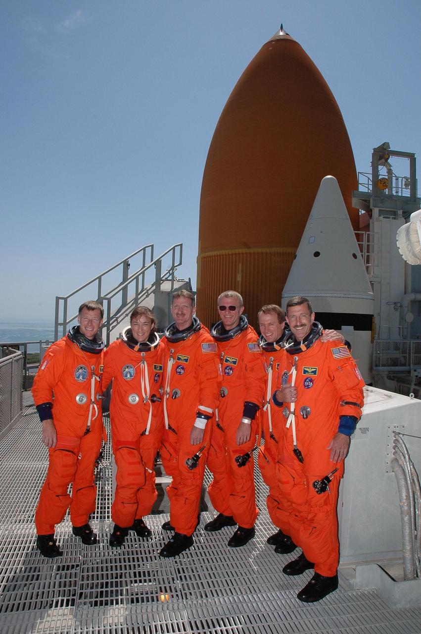 KENNEDY SPACE CENTER, FLA. -   Following a simulated launch countdown and emergency egress practice, the STS-115 crew gathers on the 215-foot level of the fixed service structure on Launch Pad 39B. From left are Pilot Christopher Ferguson, Mission Specialists Heidemarie Stefanyshyn-Piper and Joseph Tanner, Commander Brent Jett, and Mission Specialists Steven MacLean and Daniel Burbank. MacLean is with the Canadian Space Agency. Behind them loom the top of Space Shuttle Atlantis' external tank and one of the solid rocket boosters.  The TCDT is a prelaunch preparation for the mission that is scheduled to lift off in a window opening Aug. 27. During their 11-day mission to the International Space Station, the STS-115 crew will continue construction of the station and attach the payload elements, the Port 3/4 truss segment with its two large solar arrays. Photo credit: NASA/Cory Huston