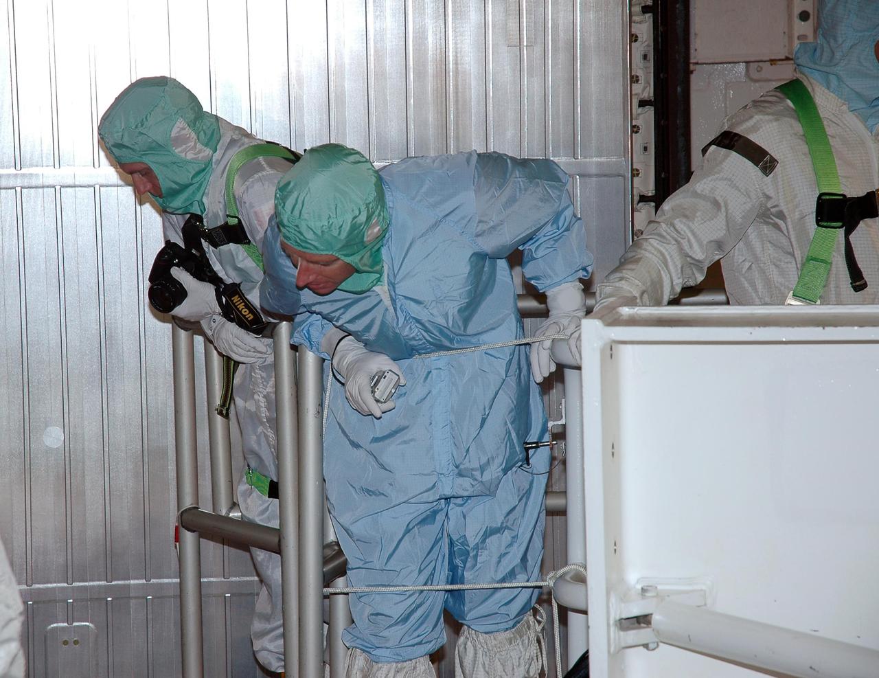 KENNEDY SPACE CENTER, FLA. -    In the payload changeout room on Launch Pad 39B, STS-115 crew members look over the mission payload one more time before launch. From left are mission specialist Steven MacLean, representing the Canadian Space Agency, and pilot Christopher Ferguson. The mission crew has been at KSC to take part in Terminal Countdown Demonstration Test activities, which include emergency egress training, a simulated launch countdown and the payload familiarization. The TCDT is a prelaunch preparation for the mission that is scheduled to lift off in a window opening Aug. 27. During their 11-day mission to the International Space Station, the STS-115 crew will continue construction of the station and attach the payload elements, the Port 3/4 truss segment with its two large solar arrays. Photo credit: NASA/Cory Huston