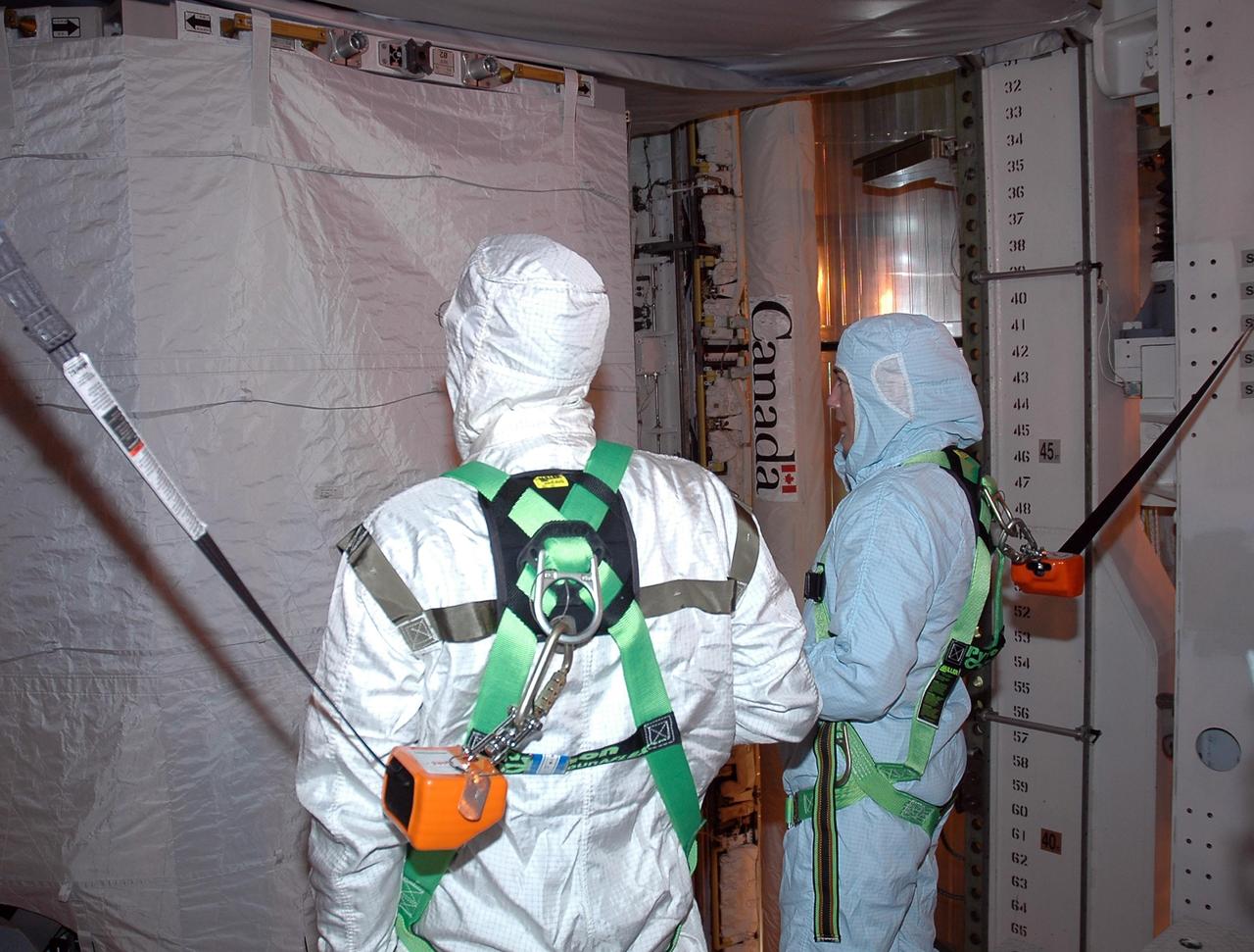 KENNEDY SPACE CENTER, FLA. -    In the payload changeout room on Launch Pad 39B, STS-115 crew members look over the mission payload one more time before launch. From left are mission specialists Joseph Tanner and Heidemarie Stefanyshyn-Piper. The mission crew has been at KSC to take part in Terminal Countdown Demonstration Test activities, which include emergency egress training, a simulated launch countdown and the payload familiarization. The TCDT is a prelaunch preparation for the mission that is scheduled to lift off in a window opening Aug. 27. During their 11-day mission to the International Space Station, the STS-115 crew will continue construction of the station and attach the payload elements, the Port 3/4 truss segment with its two large solar arrays. Photo credit: NASA/Cory Huston