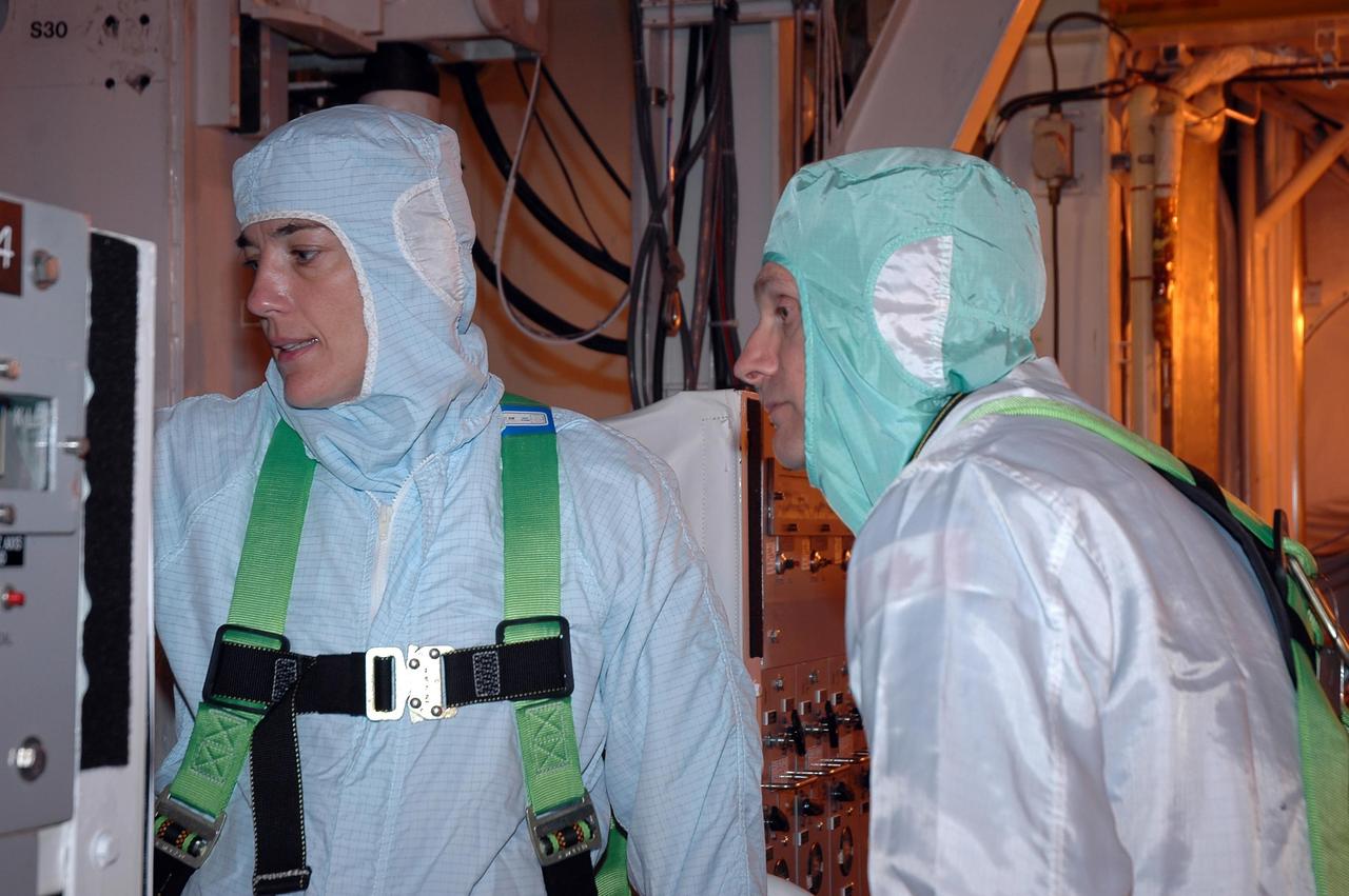 KENNEDY SPACE CENTER, FLA. -    In the payload changeout room on Launch Pad 39B, STS-115 crew members look over the mission payload one more time before launch. From left are mission specialists Heidemarie Stefanyshyn-Piper and Steven MacLean, representing the Canadian Space Agency. The mission crew has been at KSC to take part in Terminal Countdown Demonstration Test activities, which include emergency egress training, a simulated launch countdown and the payload familiarization. The TCDT is a prelaunch preparation for the mission that is scheduled to lift off in a window opening Aug. 27. During their 11-day mission to the International Space Station, the STS-115 crew will continue construction of the station and attach the payload elements, the Port 3/4 truss segment with its two large solar arrays. Photo credit: NASA/Cory Huston