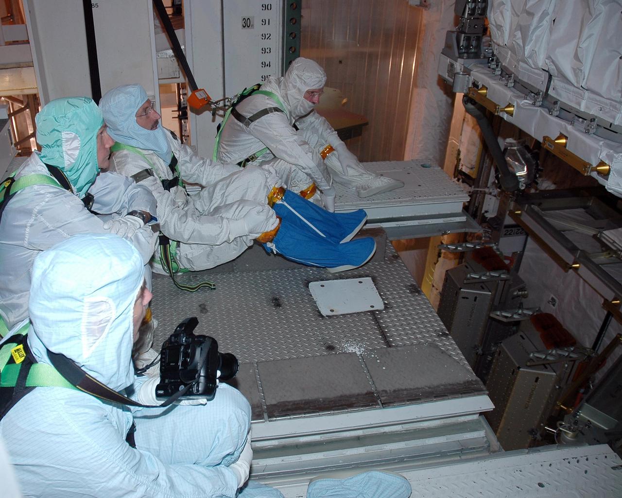 KENNEDY SPACE CENTER, FLA. -    In the payload changeout room on Launch Pad 39B, STS-115 crew members look over the mission payload one more time before launch. From left are mission specialists Heidemarie Stefanyshyn-Piper, Steven MacLean, representing the Canadian Space Agency, Daniel Burbank and Joseph Tanner. The mission crew has been at KSC to take part in Terminal Countdown Demonstration Test activities, which include emergency egress training, a simulated launch countdown and the payload familiarization. The TCDT is a prelaunch preparation for the mission that is scheduled to lift off in a window opening Aug. 27. During their 11-day mission to the International Space Station, the STS-115 crew will continue construction of the station and attach the payload elements, the Port 3/4 truss segment with its two large solar arrays. Photo credit: NASA/Cory Huston