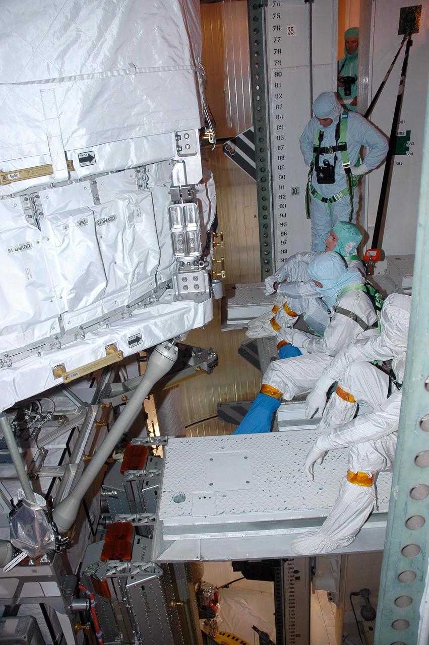 KENNEDY SPACE CENTER, FLA. -    In the payload changeout room on Launch Pad 39B, STS-115 crew members look over the mission payload one more time before launch. From front to back are mission specialists Joseph Tanner, Daniel Burbank, Steven MacLean, who represents the Canadian Space Agency, and Heidemarie Stefanyshyn-Piper. The mission crew has been at KSC to take part in Terminal Countdown Demonstration Test activities, which include emergency egress training, a simulated launch countdown and the payload familiarization. The TCDT is a prelaunch preparation for the mission that is scheduled to lift off in a window opening Aug. 27. During their 11-day mission to the International Space Station, the STS-115 crew will continue construction of the station and attach the payload elements, the Port 3/4 truss segment with its two large solar arrays. Photo credit: NASA/Cory Huston