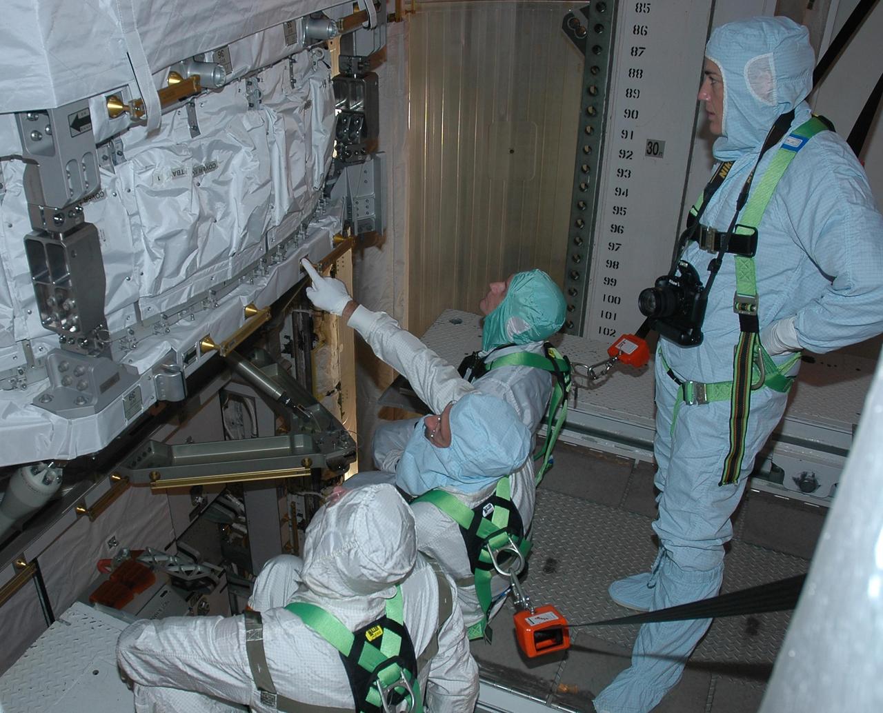 KENNEDY SPACE CENTER, FLA. -    In the payload changeout room on Launch Pad 39B, STS-115 crew members look over the mission payload one more time before launch. From left are mission specialists Joseph Tanner, Daniel Burbank, Steven MacLean, who represents the Canadian Space Agency, and Heidemarie Stefanyshyn-Piper (standing). The mission crew has been at KSC to take part in Terminal Countdown Demonstration Test activities, which include emergency egress training, a simulated launch countdown and the payload familiarization. The TCDT is a prelaunch preparation for the mission that is scheduled to lift off in a window opening Aug. 27. During their 11-day mission to the International Space Station, the STS-115 crew will continue construction of the station and attach the payload elements, the Port 3/4 truss segment with its two large solar arrays. Photo credit: NASA/Cory Huston