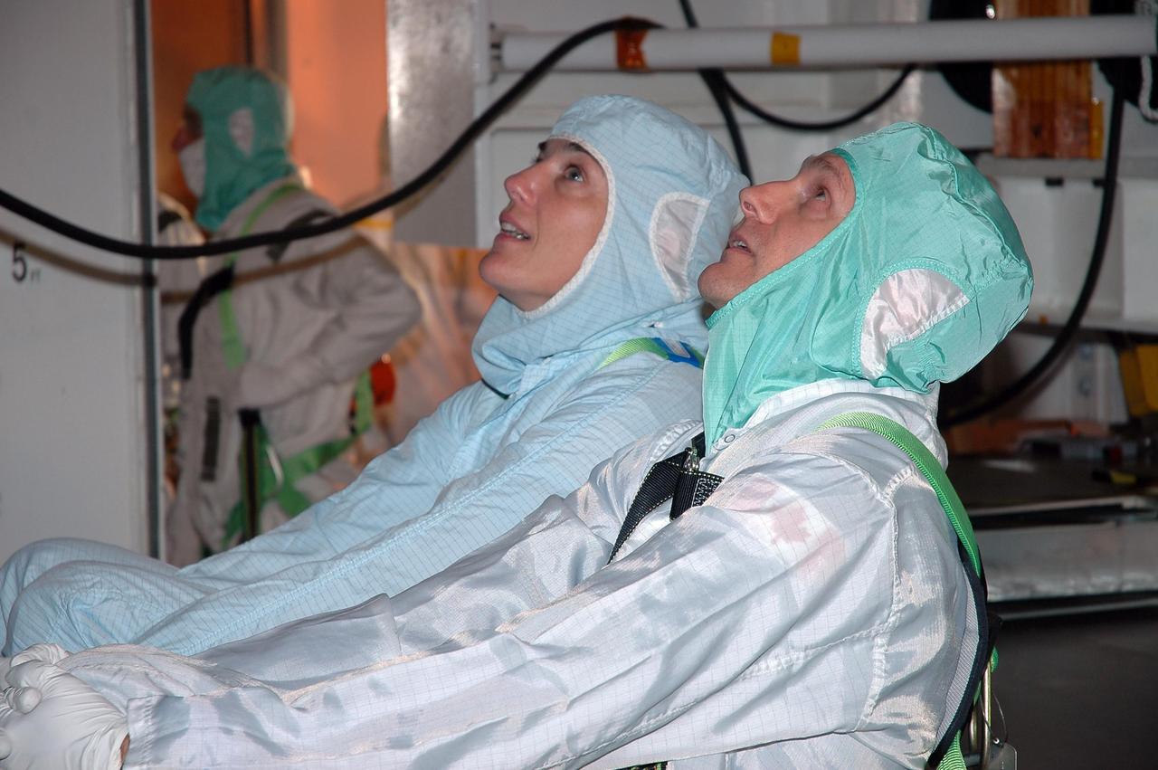 KENNEDY SPACE CENTER, FLA. -    In the payload changeout room on Launch Pad 39B, STS-115 crew members look over the mission payload one more time before launch. From left are mission specialists Heidemarie Stefanyshyn-Piper and Steven MacLean, who represents the Canadian Space Agency. The mission crew has been at KSC to take part in Terminal Countdown Demonstration Test activities, which include emergency egress training, a simulated launch countdown and the payload familiarization. The TCDT is a prelaunch preparation for the mission that is scheduled to lift off in a window opening Aug. 27. During their 11-day mission to the International Space Station, the STS-115 crew will continue construction of the station and attach the payload elements, the Port 3/4 truss segment with its two large solar arrays. Photo credit: NASA/Cory Huston