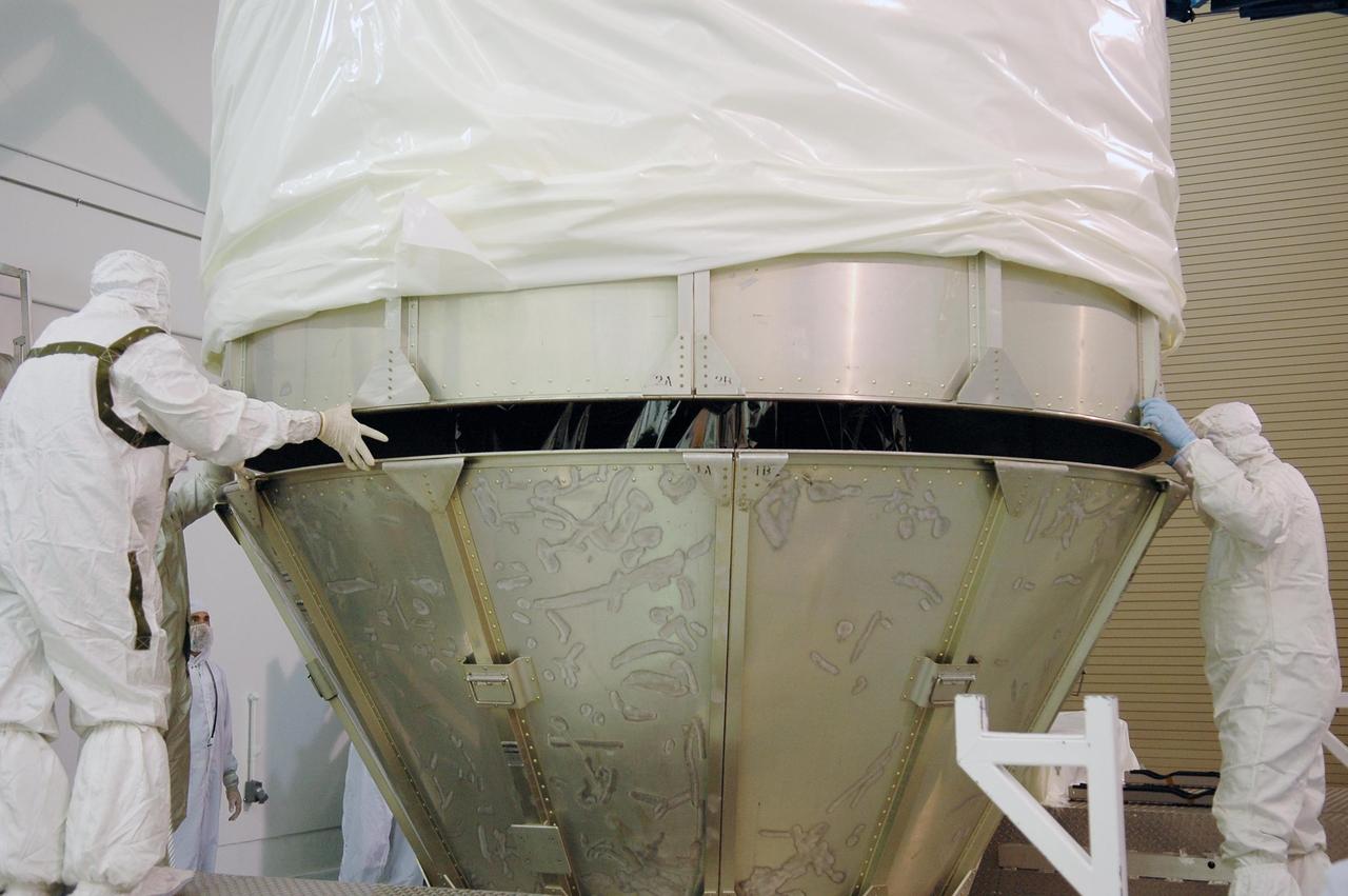 KENNEDY SPACE CENTER, FLA. - At Astrotech Space Operations in Titusville, Fla., workers help guide the upper portion of the transportation canister onto the lower portion. The canister encases the STEREO spacecraft for its move to Launch Pad 17-B at Cape Canaveral Air Force Station. STEREO stands for Solar Terrestrial Relations Observatory and comprises two spacecraft. The STEREO mission is the first to take measurements of the sun and solar wind in 3-dimension. This new view will improve our understanding of space weather and its impact on the Earth. STEREO is expected to lift off Aug. 31. Photo credit: NASA/Kim Shiflett