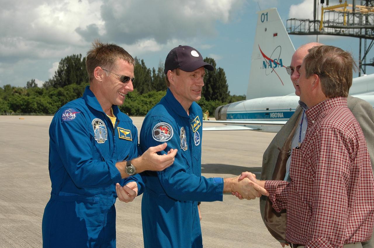 KENNEDY SPACE CENTER, FLA. -  The crew of mission STS-115 arrives at NASA Kennedy Space Center's Shuttle Landing Facility to prepare for launch on Aug. 27 to the International Space Station.  Seen here are (left to right) Pilot Christopher Ferguson and Mission Specialist Steven MacLean being greeted by KSC Associate Director Jim Hattaway and Shuttle Launch Director Mike Leinbach. The mission will deliver and install the 17-and-a-half-ton P3/P4 truss segment to the port side of the integrated truss system on the orbital outpost.  The truss includes a new set of photovoltaic solar arrays.  When unfurled to their full length of 240 feet, the arrays will provide additional power for the station in preparation for the delivery of international science modules over the next two years.  STS-115 is expected to last 11 days and includes three scheduled spacewalks.    Photo credit: NASA/Kim Shiflett