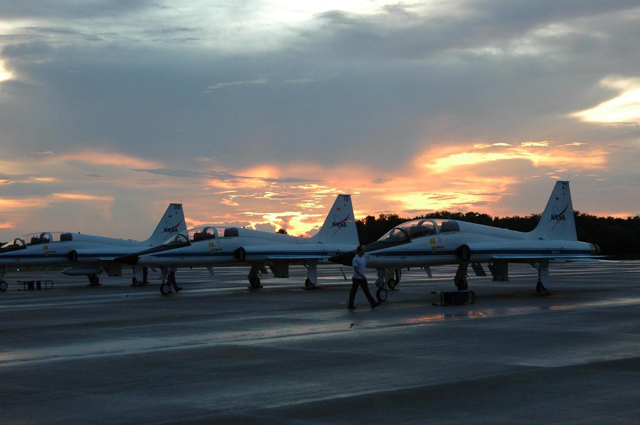 KENNEDY SPACE CENTER, FLA. -   Under cloudy skies at sunset, T-38 jet aircraft are lined up on the NASA Kennedy Space Center's Shuttle Landing Facility where STS-115 Commander Brent Jett and Pilot Christopher Ferguson will be climbing aboard the Shuttle Training Aircraft to practice landing the shuttle. STA practice is part of launch preparations.   The STA is a Grumman American Aviation-built Gulf Stream II jet that was modified to simulate an orbiter’s cockpit, motion and visual cues, and handling qualities. In flight, the STA duplicates the orbiter’s atmospheric descent trajectory from approximately 35,000 feet altitude to landing on a runway. Because the orbiter is unpowered during re-entry and landing, its high-speed glide must be perfectly executed the first time.  Mission STS-115 is scheduled to lift off about 4:30 p.m. Aug. 27.  The crew will deliver and install the P3/P4 segment to the port side of the integrated truss system on the International Space Station.  The truss includes a new set of photovoltaic solar arrays.  When unfurled to their full length of 240 feet, the arrays will provide additional power for the station in preparation for the delivery of international science modules over the next two years.  The mission is expected to last 11 days and includes three scheduled spacewalks.   Photo credit: NASA/Kim Shiflett
