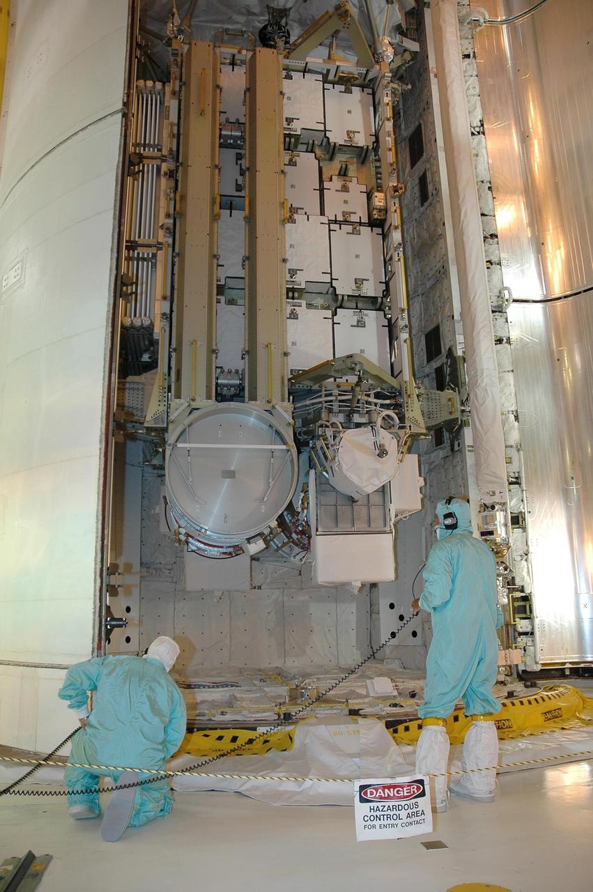 KENNEDY SPACE CENTER, FLA. -  Workers on Launch Pad 39B watch closely as Space Shuttle Atlantis' payload bay doors begin to close.  Inside the payload bay is the orbiter's cargo, the 17-and-a-half-ton P3/P4 truss segment for the International Space Station.  Mission STS-115 is scheduled to lift off about 4:30 p.m. Aug. 27.  The crew will deliver and install the P3/P4 segment to the port side of the integrated truss system on the International Space Station.  The truss includes a new set of photovoltaic solar arrays.  When unfurled to their full length of 240 feet, the arrays will provide additional power for the station in preparation for the delivery of international science modules over the next two years.  The mission is expected to last 11 days and includes three scheduled spacewalks.   Photo credit: NASA/Kim Shiflett