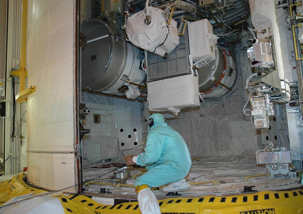 KENNEDY SPACE CENTER, FLA. -   On Launch Pad 39B, a worker checks the port payload bay door as it closes around the cargo in Space Shuttle Atlantis' payload bay. The cargo is the 17-and-a-half-ton P3/P4 truss segment for the International Space Station.   Scheduled to launch Aug. 27, Atlantis will fly on mission STS-115 with a crew of six to deliver and install the P3/P4 segment to the port side of the integrated truss system on the orbital outpost.  The truss includes a new set of photovoltaic solar arrays.  When unfurled to their full length of 240 feet, the arrays will provide additional power for the station in preparation for the delivery of international science modules over the next two years.  STS-115 is expected to last 11 days and includes three scheduled spacewalks.  Photo credit: NASA/Jack Pfaller