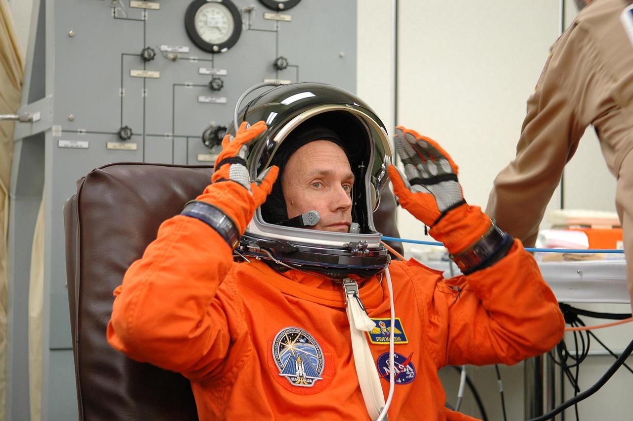 KENNEDY SPACE CENTER, FLA. - STS-115 Mission Specialist Steven MacLean tests the fit of his helmet before launching on Aug. 27. MacLean, who represents the Canadian Space Agency, will be making his second flight on a shuttle. Mission STS-115 is scheduled to lift off about 4:30 p.m. Aug. 27 on Space Shuttle Atlantis. The crew will deliver and install the P3/P4 segment to the port side of the integrated truss system on the International Space Station. The truss includes a new set of photovoltaic solar arrays. When unfurled to their full length of 240 feet, the arrays will provide additional power for the station in preparation for the delivery of international science modules over the next two years. The mission is expected to last 11 days and includes three scheduled spacewalks. Photo credit: NASA/Kim Shiflett