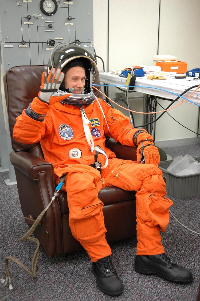 KENNEDY SPACE CENTER, FLA. - During suit check, STS-115 Mission Specialist Steven MacLean waves in confidence about the launch on Space Shuttle Atlantis on Aug. 27. MacLean, who represents the Canadian Space Agency, will be making his second flight on a shuttle. Mission STS-115 is scheduled to lift off about 4:30 p.m. Aug. 27. The crew will deliver and install the P3/P4 segment to the port side of the integrated truss system on the International Space Station. The truss includes a new set of photovoltaic solar arrays. When unfurled to their full length of 240 feet, the arrays will provide additional power for the station in preparation for the delivery of international science modules over the next two years. The mission is expected to last 11 days and includes three scheduled spacewalks. Photo credit: NASA/Kim Shiflett