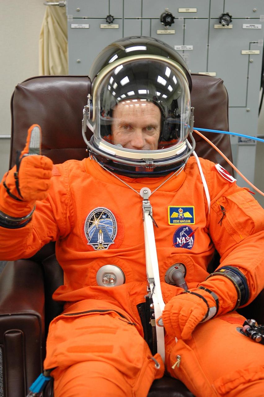 KENNEDY SPACE CENTER, FLA. - During suit check, STS-115 Mission Specialist Steven MacLean signals confidence about the launch on Space Shuttle Atlantis on Aug. 27. MacLean, who represents the Canadian Space Agency, will be making his second flight on a shuttle. Mission STS-115 is scheduled to lift off about 4:30 p.m. Aug. 27. The crew will deliver and install the P3/P4 segment to the port side of the integrated truss system on the International Space Station. The truss includes a new set of photovoltaic solar arrays. When unfurled to their full length of 240 feet, the arrays will provide additional power for the station in preparation for the delivery of international science modules over the next two years. The mission is expected to last 11 days and includes three scheduled spacewalks. Photo credit: NASA/Kim Shiflett