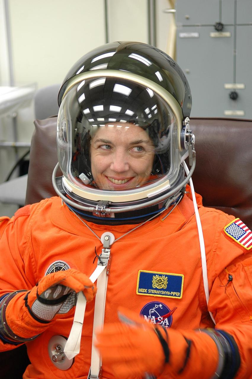 KENNEDY SPACE CENTER, FLA. -  STS-115 Mission Specialist Heidemarie Stefanyshyn-Piper gives one last tug on the strap of her launch suit. Piper is making her first flight on a shuttle.  She and other crew members are checking their launch suits and apparatus before the launch on Aug. 27. Mission STS-115 is scheduled to lift off about 4:30 p.m. Aug. 27 on Space Shuttle Atlantis.  The crew will deliver and install the P3/P4 segment to the port side of the integrated truss system on the International Space Station.  The truss includes a new set of photovoltaic solar arrays.  When unfurled to their full length of 240 feet, the arrays will provide additional power for the station in preparation for the delivery of international science modules over the next two years.  The mission is expected to last 11 days and includes three scheduled spacewalks.   Photo credit: NASA/Kim Shiflett