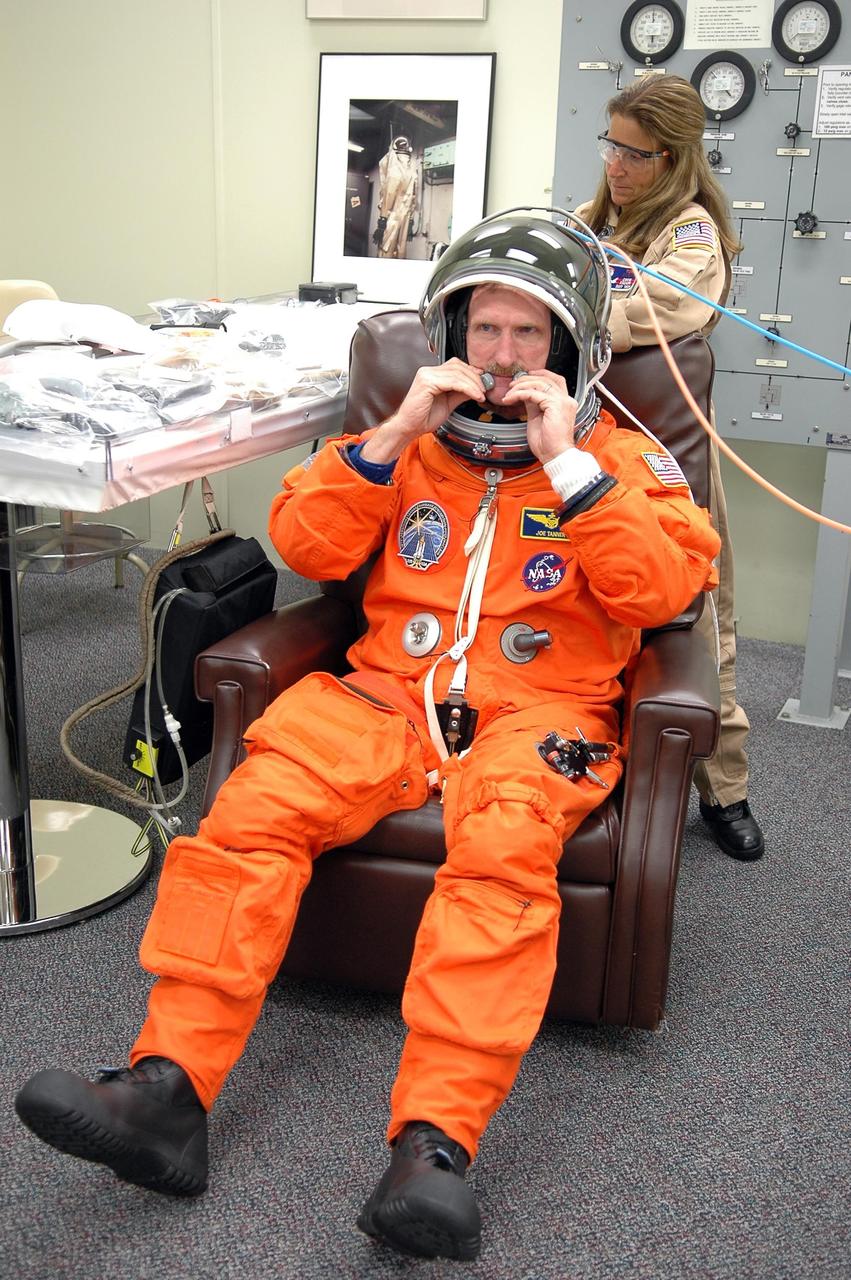 KENNEDY SPACE CENTER, FLA. -  STS-115 Mission Specialist Joseph Tanner checks the equipment on the head set in his launch suit.  Tanner is making his fourth flight on a shuttle.He and other crew members are checking their launch suits and apparatus before the launch on Space Shuttle Atlantis on Aug. 27.  Mission STS-115 is scheduled to lift off about 4:30 p.m. Aug. 27.  The crew will deliver and install the P3/P4 segment to the port side of the integrated truss system on the International Space Station.  The truss includes a new set of photovoltaic solar arrays.  When unfurled to their full length of 240 feet, the arrays will provide additional power for the station in preparation for the delivery of international science modules over the next two years.  The mission is expected to last 11 days and includes three scheduled spacewalks.   Photo credit: NASA/Kim Shiflett