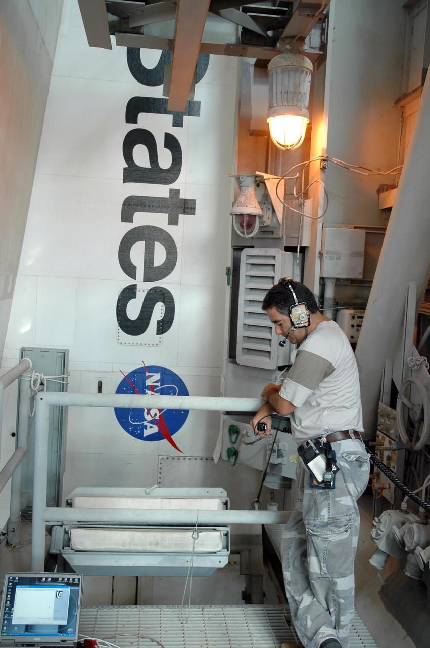 KENNEDY SPACE CENTER, FLA. -  On Launch Pad 39B, a worker monitors data during evaluation of systems at the pad after a lightning strike Aug. 25.  Preparations continue on the pad for launch of Atlantis on mission STS-115 as early as Aug. 29.  However, preparations are also underway for a rollback of Atlantis to the Vehicle Assembly Building due to Hurricane Ernesto.  The rollback will be determined by the mission management team based on information about Hurricane Ernesto and its path through Florida. Atlantis has been poised on Launch Pad 39B for liftoff on mission STS-115 to the International Space Station to deliver the P3/P4 truss segment.  Photo credit: NASA/Jack Pfaller