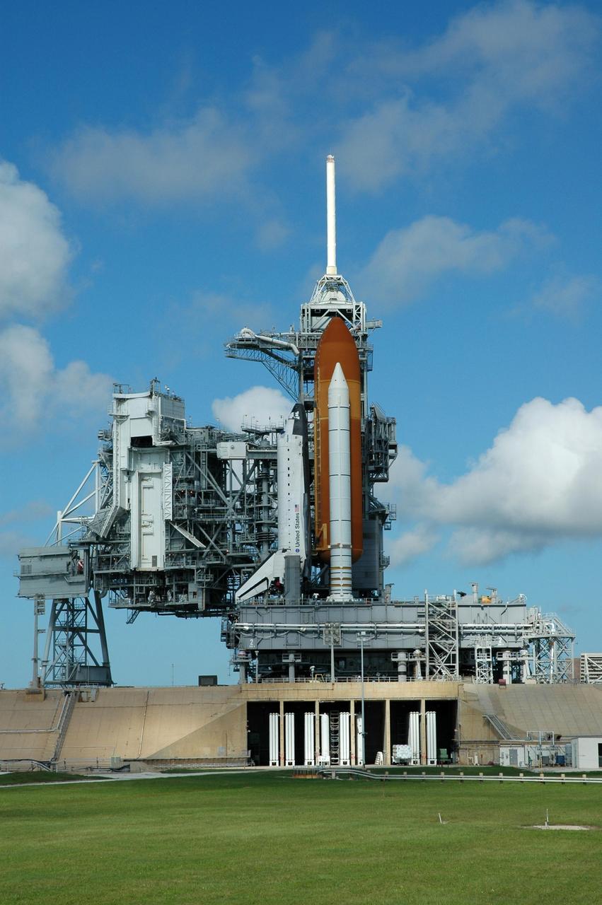 KENNEDY SPACE CENTER, FLA. - On Launch Pad 39B, the rotating service structure has been rolled away from Space Shuttle Atlantis, sitting on the mobile launcher platform. The crawler-transporter, which has moved underneath, will lift and carry both back to the Vehicle Assembly Building (VAB), approximately 4 miles away. Despite the clear blue skies, the rollback is a safety precaution as the area waits for the arrival of Tropical Storm Ernesto. The storm is forecast to be bringing 58-mph to 70-mph winds in the next 24 hours. The shuttle will be moved into high bay 2, on the southwest side of the VAB, for protection from the storm. Photo credit: NASA/Jim Grossmann