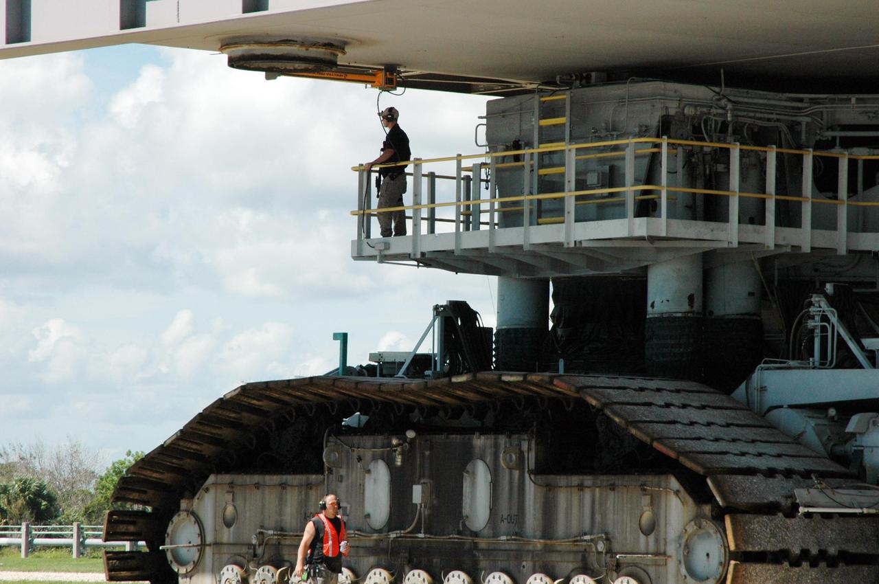 KENNEDY SPACE CENTER, FLA. - Engineers keep watch on the crawler-transporter as it carries Space Shuttle Atlantis and the mobile launcher platform back to the Vehicle Assembly Building. First motion off the pad was at 10:04 a.m. EDT. The crawler is 131 feet long, 113 feet wide and 20 feet high. It weights 5.5 million pounds unloaded. The combined weight of crawler, mobile launcher platform and a space shuttle is 12 million pounds. Unloaded, the crawler moves at 2 mph. Loaded, the snail's pace slows to 1 mph. The rollback is a safety precaution as the area waits for the arrival of Tropical Storm Ernesto. The storm is forecast to be bringing 58-mph to 70-mph winds in the next 24 hours. The shuttle will be moved into high bay 2, on the southwest side of the VAB, for protection from the storm. Photo credit: NASA/Ken Thornsley