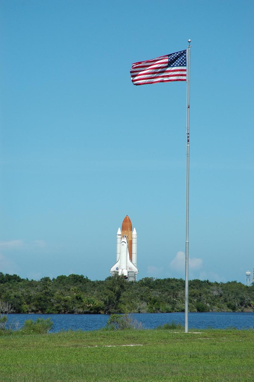 KENNEDY SPACE CENTER, FLA. -    Viewed from the NASA News Center across the turn basin in the Launch Complex 39 Area, Space Shuttle Atlantis continues its slow crawl toward the Vehicle Assembly Building from Launch Pad 39B. After this photo was taken, the decision was made to return the shuttle to the launch pad.  The rollback was a safety precaution as the area waits for the arrival of Tropical Storm Ernesto.  The storm was forecast to be bringing 58-mph to 70-mph winds in the next 24 hours.   The revised forecast of lesser winds expected from Ernesto and its projected direction convinced Launch Integration Manager LeRoy Cain and Shuttle Launch Director Mike Leinbach to return the shuttle to the launch pad. Photo credit: NASA/Kim Shiflett