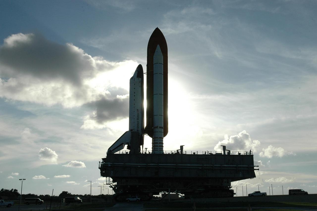 KENNEDY SPACE CENTER, FLA. -  Dark clouds silhouette Space Shuttle Atlantis as it rolls back to Launch Pad 39B atop the crawler-transporter. The shuttle had been moved off the launch pad due to concerns about the impact of Tropical Storm Ernesto, expected within 24 hours.  The forecast of lesser winds expected from Ernesto and its projected direction convinced Launch Integration Manager LeRoy Cain and Shuttle Launch Director Mike Leinbach to return the shuttle to the launch pad.  Photo credit: NASA/Kim Shiflett