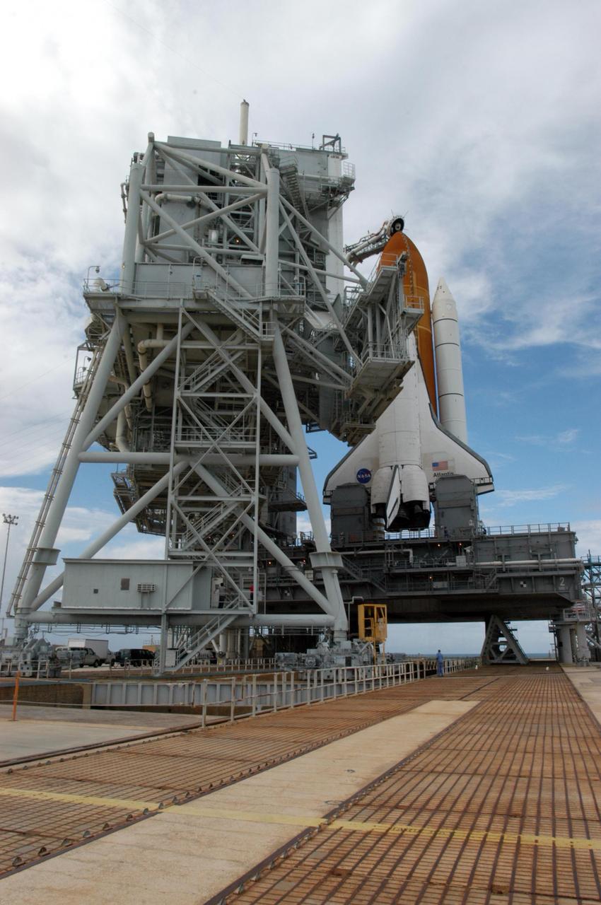 KENNEDY SPACE CENTER, FLA. - The rotating service structure (left) on Launch Pad 39B begins rolling back to reveal Space Shuttle Atlantis. The RSS provides protected access to the orbiter for changeout and servicing of payloads at the pad and then is rolled away before liftoff. Atlantis is scheduled to launch Sept. 6 at 12:29 p.m. EDT on mission STS-115. During the mission, Atlantis' astronauts will deliver and install the 17.5-ton, bus-sized P3/P4 integrated truss segment on the station. The girder-like truss includes a set of giant solar arrays, batteries and associated electronics and will provide one-fourth of the total power-generation capability for the completed station. This mission is the 116th space shuttle flight, the 27th flight for orbiter Atlantis, and the 19th U.S. flight to the International Space Station. STS-115 is scheduled to last 11 days with a planned KSC landing at about 8:03 a.m. EDT on Sept. 17. Photo credit: NASA/George Shelton