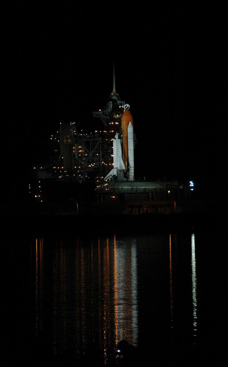 KENNEDY SPACE CENTER, FLA. - The lights on Launch Pad 39B paint columns of light in the water next to the pad where Space Shuttle Atlantis is illuminated. Atlantis was originally scheduled to launch on Aug. 27, but a scrub was called by mission managers due to a concern with fuel cell 1. Atlantis is scheduled to lift off at 11:41 a.m. EDT Sept. 8. During the STS-115 mission, Atlantis' astronauts will deliver and install the 17.5-ton, bus-sized P3/P4 integrated truss segment on the station. The girder-like truss includes a set of giant solar arrays, batteries and associated electronics and will provide one-fourth of the total power-generation capability for the completed station. This mission is the 116th space shuttle flight, the 27th flight for orbiter Atlantis, and the 19th U.S. flight to the ISS. STS-115 is scheduled to last 11 days with a planned landing at KSC. Photo credit: NASA/Ken Thornsley