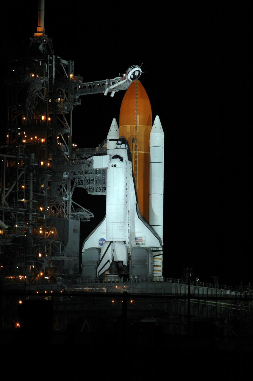 KENNEDY SPACE CENTER, FLA. - Space Shuttle Atlantis is illuminated on Launch Pad 39B, while amber lights on the fixed service structure give a surreal appearance. Seen above the golden external tank is the vent hood (known as the "beanie cap") at the end of the gaseous oxygen vent arm. Vapors are created as the liquid oxygen in the external tank boil off. The hood vents the gaseous oxygen vapors away from the space shuttle vehicle. Lower down, and next to Atlantis, is the White Room at the end of the orbiter access arm. The White Room provides entry into the orbiter through the hatch. Atlantis was originally scheduled to launch on Aug. 27, but a scrub was called by mission managers due to a concern with fuel cell 1. Atlantis is scheduled to lift off at 11:41 a.m. EDT Sept. 8. During the STS-115 mission, Atlantis' astronauts will deliver and install the 17.5-ton, bus-sized P3/P4 integrated truss segment on the station. The girder-like truss includes a set of giant solar arrays, batteries and associated electronics and will provide one-fourth of the total power-generation capability for the completed station. This mission is the 116th space shuttle flight, the 27th flight for orbiter Atlantis, and the 19th U.S. flight to the ISS. STS-115 is scheduled to last 11 days with a planned landing at KSC. Photo credit: NASA/Ken Thornsley