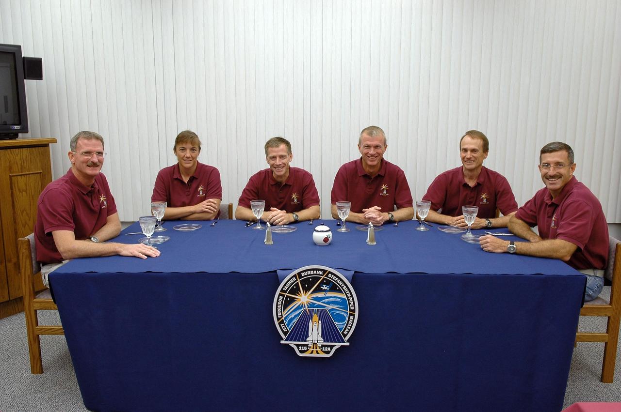 KENNEDY SPACE CENTER, FLA. -  After a week's delay of launching due to weather and technical issues, the crew of mission STS-115 enjoy the traditional breakfast before their second attempt to launch on Space Shuttle Atlantis.  Seated left to right are Mission Specialists Joseph Tanner and Heidemarie Stefanyshyn-Piper, Pilot Christopher Ferguson, Commander Brent Jett and Mission Specialists Steven MacLean and Daniel Burbank.  MacLean is with the Canadian Space Agency.  Following the breakfast, the crew will don their launch suits before heading to Launch Pad 39B.  During the STS-115 mission, Atlantis' astronauts will deliver and install the 17.5-ton, bus-sized P3/P4 integrated truss segment on the station. The girder-like truss includes a set of giant solar arrays, batteries and associated electronics and will provide one-fourth of the total power-generation capability for the completed station. This mission is the 116th space shuttle flight, the 27th flight for orbiter Atlantis, and the 19th U.S. flight to the International Space Station. STS-115 is scheduled to last 11 days with a planned landing at KSC.   Photo credit: NASA/Kim Shiflett