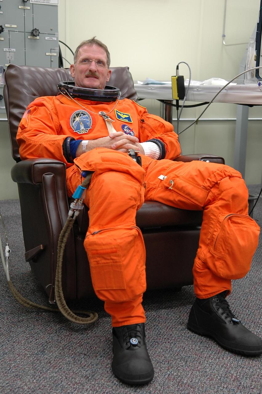 KENNEDY SPACE CENTER, FLA. -  In the Operations and Checkout Building at NASA Kennedy Space Center, STS-115 Mission Specialist Joseph Tanner dons his launch and re-entry suit before heading to the launch pad.  Tanner is making his fourth shuttle flight on this mission to the International Space Station aboard Space Shuttle Atlantis. On its second attempt for launch, Atlantis is scheduled to lift off at 11:41 a.m. EDT today from Launch Pad 39B.  During the STS-115 mission, Atlantis' astronauts will deliver and install the 17.5-ton, bus-sized P3/P4 integrated truss segment on the station. The girder-like truss includes a set of giant solar arrays, batteries and associated electronics and will provide one-fourth of the total power-generation capability for the completed station. This mission is the 116th space shuttle flight, the 27th flight for orbiter Atlantis, and the 19th U.S. flight to the ISS. STS-115 is scheduled to last 11 days with a planned landing at KSC.  Photo credit: NASA/Kim Shiflett