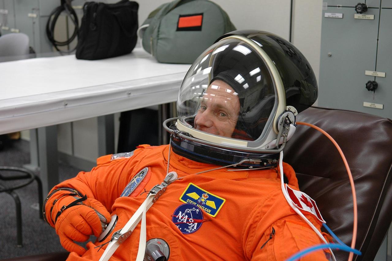KENNEDY SPACE CENTER, FLA. -   In the Operations and Checkout Building at NASA Kennedy Space Center, STS-115 Mission Specialist Steven MacLean dons his launch and re-entry suit before heading to the launch pad. MacLean is with the Canadian Space Agency.  MacLean is making his second shuttle flight on this mission to the International Space Station aboard Space Shuttle Atlantis. On its second attempt for launch, Atlantis is scheduled to lift off at 11:41 a.m. EDT today from Launch Pad 39B.  During the STS-115 mission, Atlantis' astronauts will deliver and install the 17.5-ton, bus-sized P3/P4 integrated truss segment on the station. The girder-like truss includes a set of giant solar arrays, batteries and associated electronics and will provide one-fourth of the total power-generation capability for the completed station. This mission is the 116th space shuttle flight, the 27th flight for orbiter Atlantis, and the 19th U.S. flight to the ISS. STS-115 is scheduled to last 11 days with a planned landing at KSC.  Photo credit: NASA/Kim Shiflett