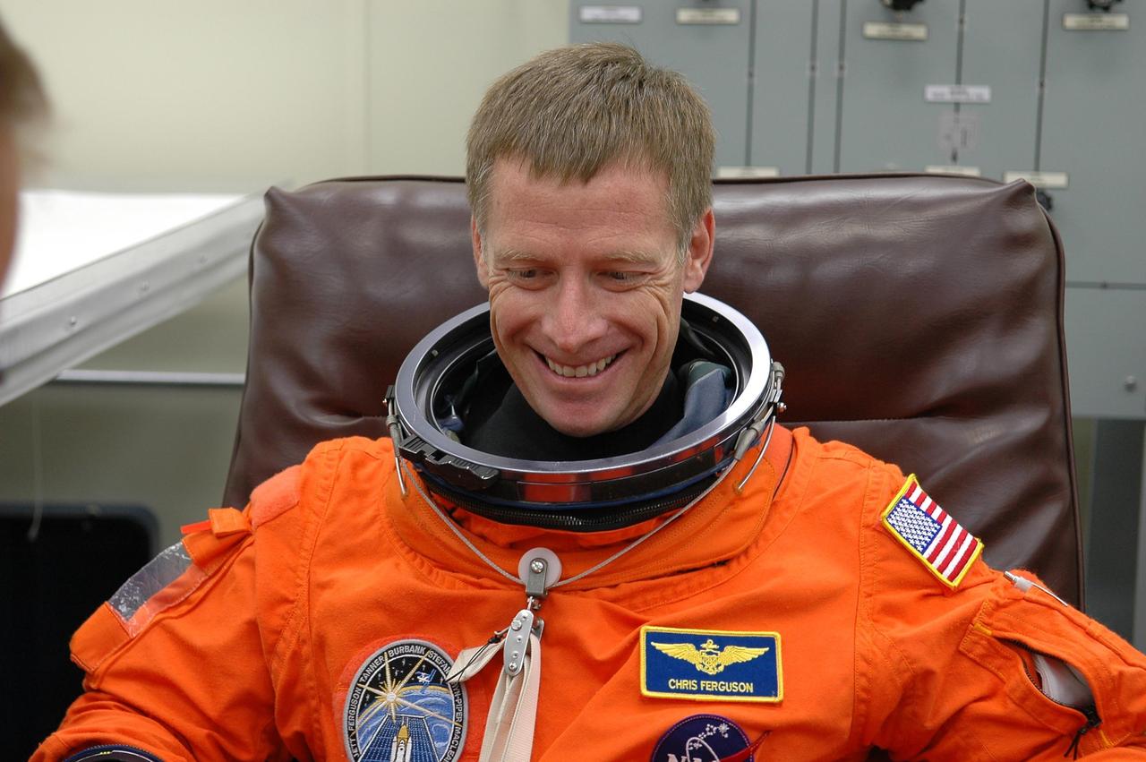 KENNEDY SPACE CENTER, FLA. -  In the Operations and Checkout Building at NASA Kennedy Space Center, STS-115 Pilot Christopher Ferguson dons his launch and re-entry suit before heading to the launch pad. Ferguson is making his first shuttle flight on this mission to the International Space Station aboard Space Shuttle Atlantis.  On its second attempt for launch, Atlantis is scheduled to lift off at 11:41 a.m. EDT today from Launch Pad 39B.  During the STS-115 mission, Atlantis' astronauts will deliver and install the 17.5-ton, bus-sized P3/P4 integrated truss segment on the station. The girder-like truss includes a set of giant solar arrays, batteries and associated electronics and will provide one-fourth of the total power-generation capability for the completed station. This mission is the 116th space shuttle flight, the 27th flight for orbiter Atlantis, and the 19th U.S. flight to the ISS. STS-115 is scheduled to last 11 days with a planned landing at KSC.  Photo credit: NASA/Kim Shiflett