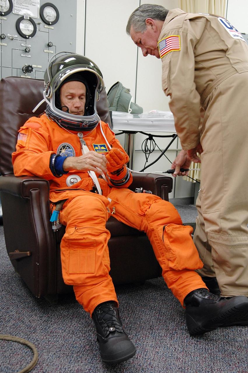 KENNEDY SPACE CENTER, FLA. -  In the Operations and Checkout Building at NASA Kennedy Space Center, STS-115 Mission Specialist Steven MacLean checks his glove during suitup before heading to the launch pad. MacLean is with the Canadian Space Agency.  MacLean is making his second shuttle flight on this mission to the International Space Station aboard Space Shuttle Atlantis. On its second attempt for launch, Atlantis is scheduled to lift off at 11:41 a.m. EDT today from Launch Pad 39B.  During the STS-115 mission, Atlantis' astronauts will deliver and install the 17.5-ton, bus-sized P3/P4 integrated truss segment on the station. The girder-like truss includes a set of giant solar arrays, batteries and associated electronics and will provide one-fourth of the total power-generation capability for the completed station. This mission is the 116th space shuttle flight, the 27th flight for orbiter Atlantis, and the 19th U.S. flight to the ISS. STS-115 is scheduled to last 11 days with a planned landing at KSC.  Photo credit: NASA/Kim Shiflett