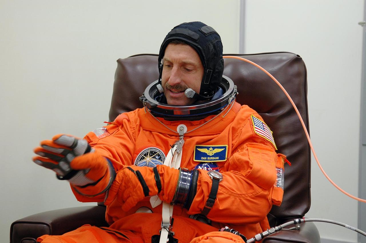 KENNEDY SPACE CENTER, FLA. -  In the Operations and Checkout Building at NASA Kennedy Space Center, STS-115 Mission Specialist Daniel Burbank adjusts his glove during suitup before heading to the launch pad.  Burbank is making his second shuttle flight on this mission to the International Space Station aboard Space Shuttle Atlantis. On its second attempt for launch, Atlantis is scheduled to lift off at 11:41 a.m. EDT today from Launch Pad 39B.  During the STS-115 mission, Atlantis' astronauts will deliver and install the 17.5-ton, bus-sized P3/P4 integrated truss segment on the station. The girder-like truss includes a set of giant solar arrays, batteries and associated electronics and will provide one-fourth of the total power-generation capability for the completed station. This mission is the 116th space shuttle flight, the 27th flight for orbiter Atlantis, and the 19th U.S. flight to the ISS. STS-115 is scheduled to last 11 days with a planned landing at KSC.  Photo credit: NASA/Kim Shiflett
