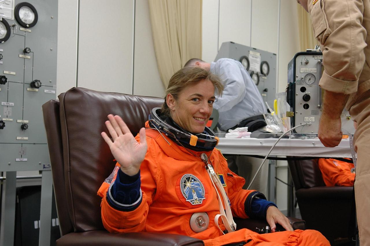 KENNEDY SPACE CENTER, FLA. -  STS-115 Mission Specialist Heidemarie Stefanyshyn-Piper waves during suitup in the Operations and Checkout Building at NASA Kennedy Space Center.  She is making her first shuttle flight on this mission to the International Space Station aboard Space Shuttle Atlantis.  On its second attempt for launch, Atlantis is scheduled to lift off at 11:41 a.m. EDT today from Launch Pad 39B.  During the STS-115 mission, Atlantis' astronauts will deliver and install the 17.5-ton, bus-sized P3/P4 integrated truss segment on the station. The girder-like truss includes a set of giant solar arrays, batteries and associated electronics and will provide one-fourth of the total power-generation capability for the completed station. This mission is the 116th space shuttle flight, the 27th flight for orbiter Atlantis, and the 19th U.S. flight to the ISS. STS-115 is scheduled to last 11 days with a planned landing at KSC.  Photo credit: NASA/Kim Shiflett