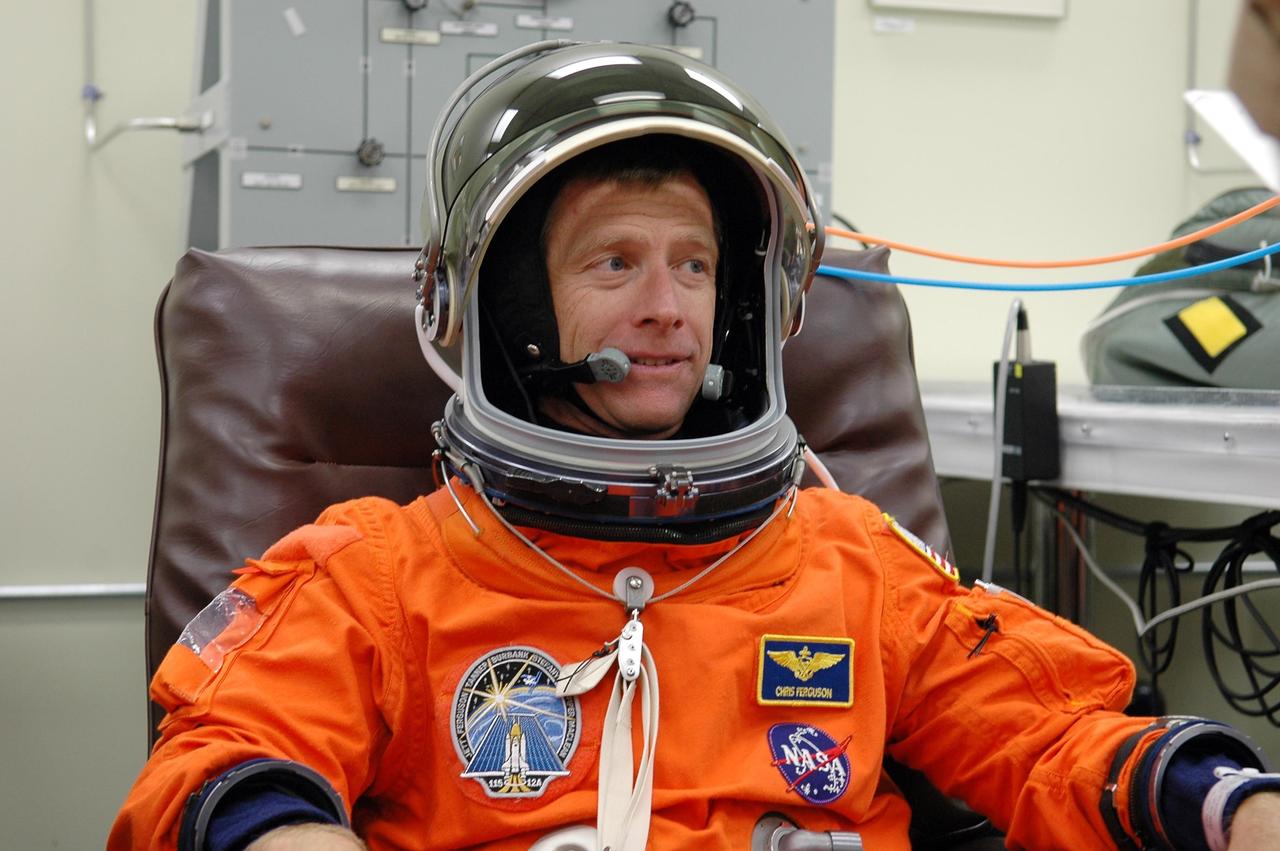KENNEDY SPACE CENTER, FLA. -  In the Operations and Checkout Building at NASA Kennedy Space Center, STS-115 Pilot Christopher Ferguson checks his helmet during suitup before heading to the launch pad. Ferguson is making his first shuttle flight on this mission to the International Space Station aboard Space Shuttle Atlantis.  On its second attempt for launch, Atlantis is scheduled to lift off at 11:41 a.m. EDT today from Launch Pad 39B.  During the STS-115 mission, Atlantis' astronauts will deliver and install the 17.5-ton, bus-sized P3/P4 integrated truss segment on the station. The girder-like truss includes a set of giant solar arrays, batteries and associated electronics and will provide one-fourth of the total power-generation capability for the completed station. This mission is the 116th space shuttle flight, the 27th flight for orbiter Atlantis, and the 19th U.S. flight to the ISS. STS-115 is scheduled to last 11 days with a planned landing at KSC.  Photo credit: NASA/Kim Shiflett