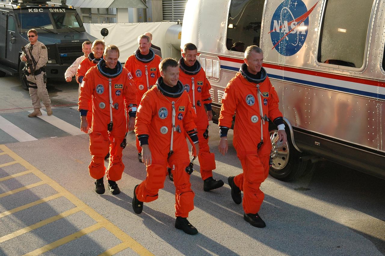 KENNEDY SPACE CENTER, FLA. -   The STS-115 crew members walk toward the Astrovan that will take them to Launch Pad 39B.  Seen left to right are Mission Specialists Heidemarie Stefanyshyn-Piper, Steven MacLean, Joseph Tanner and Daniel Burbank; Pilot Christopher Ferguson; and Commander Brent Jett.  This is the second attempt at launch after a week's postponement due to weather and technical concerns. Atlantis is scheduled to lift off at 11:41 a.m. EDT on this date from Launch Pad 39B.  During the STS-115 mission, Atlantis' astronauts will deliver and install the 17.5-ton, bus-sized P3/P4 integrated truss segment on the station. The girder-like truss includes a set of giant solar arrays, batteries and associated electronics and will provide one-fourth of the total power-generation capability for the completed station. This mission is the 116th space shuttle flight, the 27th flight for orbiter Atlantis, and the 19th U.S. flight to the ISS. STS-115 is scheduled to last 11 days with a planned landing at KSC.  Photo credit: NASA/Kim Shiflett