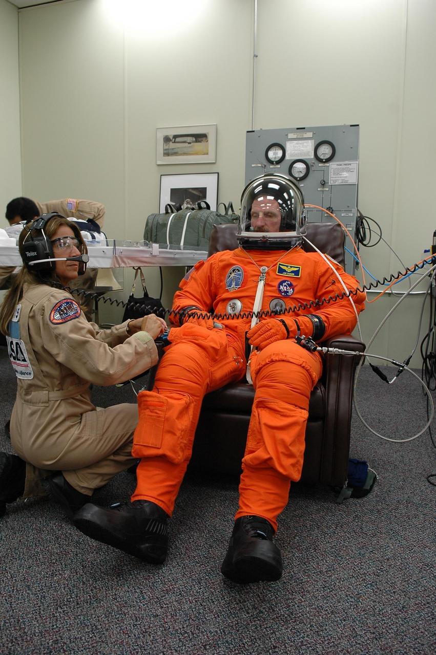 KENNEDY SPACE CENTER, FLA. -   In the Operations and Checkout Building at NASA Kennedy Space Center, STS-115 Mission Specialist Joseph Tanner dons his launch and re-entry suit before heading to the launch pad for another attempt at liftoff.   The launch attempt on Sept. 8 was scrubbed due to an issue with a fuel cut-off sensor system inside the external fuel tank. This is one of several systems that protect the shuttle's main engines by triggering their shutdown if fuel runs unexpectedly low.  Liftoff today is scheduled for 11:15 a.m. EDT.  During the STS-115 mission, Atlantis' astronauts will deliver and install the 17.5-ton, bus-sized P3/P4 integrated truss segment on the station. The girder-like truss includes a set of giant solar arrays, batteries and associated electronics and will provide one-fourth of the total power-generation capability for the completed station. This mission is the 116th space shuttle flight, the 27th flight for orbiter Atlantis, and the 19th U.S. flight to the ISS. STS-115 is scheduled to last 11 days with a planned landing at KSC.  Photo credit: NASA/Kim Shiflett