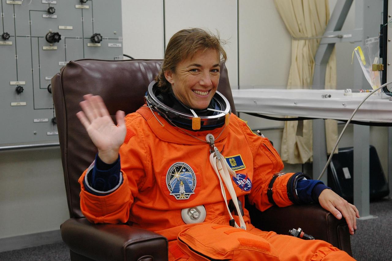 KENNEDY SPACE CENTER, FLA. -  In the Operations and Checkout Building at NASA Kennedy Space Center, STS-115 Mission Specialist Heidemarie Stefanyshyn-Piper is eager for another attempt at liftoff.   The launch attempt on Sept. 8 was scrubbed due to an issue with a fuel cut-off sensor system inside the external fuel tank. This is one of several systems that protect the shuttle's main engines by triggering their shutdown if fuel runs unexpectedly low.  During the STS-115 mission, Atlantis' astronauts will deliver and install the 17.5-ton, bus-sized P3/P4 integrated truss segment on the station. The girder-like truss includes a set of giant solar arrays, batteries and associated electronics and will provide one-fourth of the total power-generation capability for the completed station. This mission is the 116th space shuttle flight, the 27th flight for orbiter Atlantis, and the 19th U.S. flight to the ISS. STS-115 is scheduled to last 11 days with a planned landing at KSC.  Photo credit: NASA/Kim Shiflett