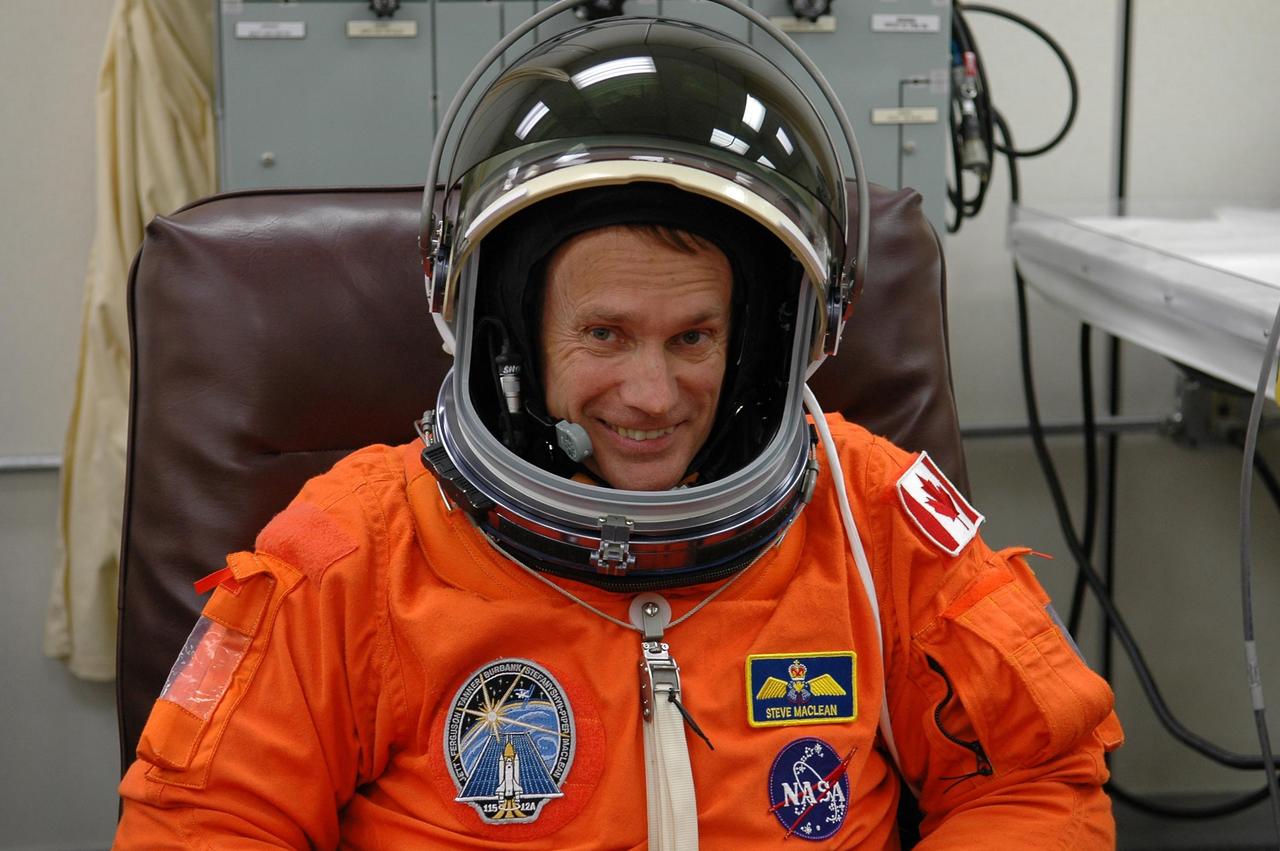 KENNEDY SPACE CENTER, FLA. -  In the Operations and Checkout Building at NASA Kennedy Space Center, STS-115 Mission Specialist Steven MacLean dons his helmet to complete suiting up for another attempt at liftoff.  MacLean is with the Canadian Space Agency.  The launch attempt on Sept. 8 was scrubbed due to an issue with a fuel cut-off sensor system inside the external fuel tank. This is one of several systems that protect the shuttle's main engines by triggering their shutdown if fuel runs unexpectedly low.  During the STS-115 mission, Atlantis' astronauts will deliver and install the 17.5-ton, bus-sized P3/P4 integrated truss segment on the station. The girder-like truss includes a set of giant solar arrays, batteries and associated electronics and will provide one-fourth of the total power-generation capability for the completed station. This mission is the 116th space shuttle flight, the 27th flight for orbiter Atlantis, and the 19th U.S. flight to the ISS. STS-115 is scheduled to last 11 days with a planned landing at KSC.  Photo credit: NASA/Kim Shiflett