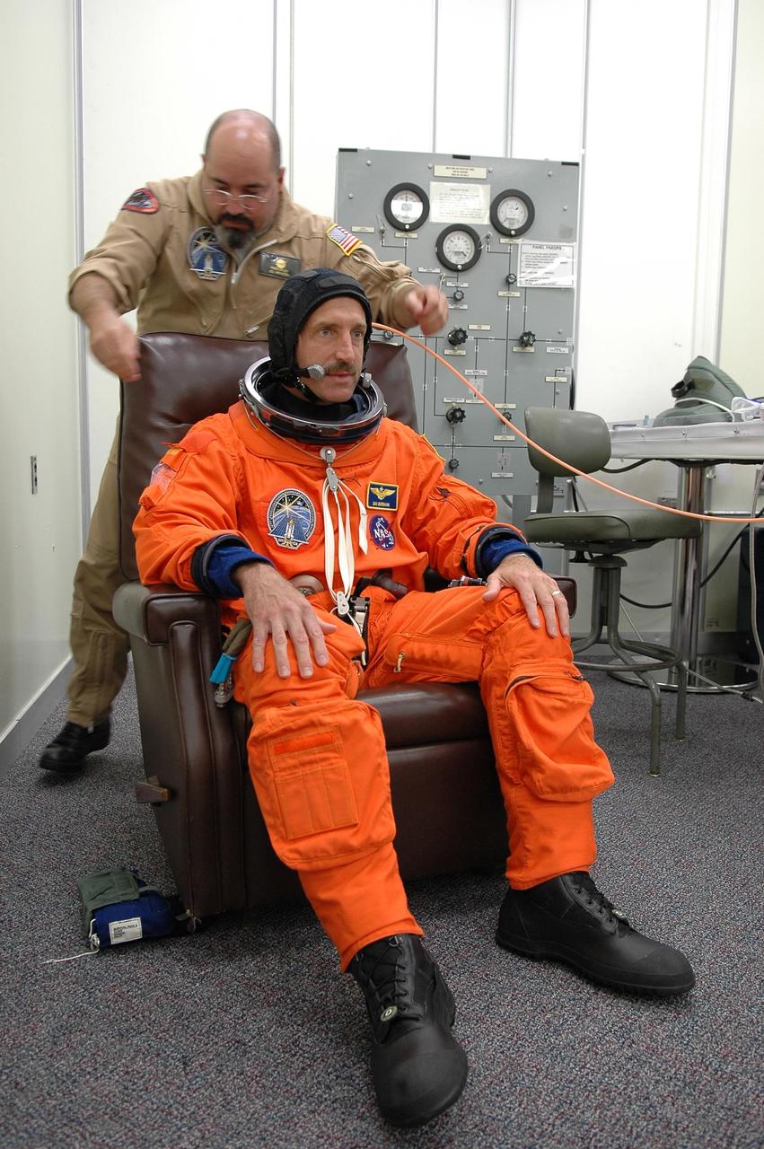 KENNEDY SPACE CENTER, FLA. -  In the Operations and Checkout Building at NASA Kennedy Space Center, STS-115 Mission Specialist Daniel Burbank dons his launch and re-entry suit before heading to the launch pad for another attempt at liftoff.  The launch attempt on Sept. 8 was scrubbed due to an issue with a fuel cut-off sensor system inside the external fuel tank. This is one of several systems that protect the shuttle's main engines by triggering their shutdown if fuel runs unexpectedly low.  During the STS-115 mission, Atlantis' astronauts will deliver and install the 17.5-ton, bus-sized P3/P4 integrated truss segment on the station. The girder-like truss includes a set of giant solar arrays, batteries and associated electronics and will provide one-fourth of the total power-generation capability for the completed station. This mission is the 116th space shuttle flight, the 27th flight for orbiter Atlantis, and the 19th U.S. flight to the ISS. STS-115 is scheduled to last 11 days with a planned landing at KSC.  Photo credit: NASA/Kim Shiflett