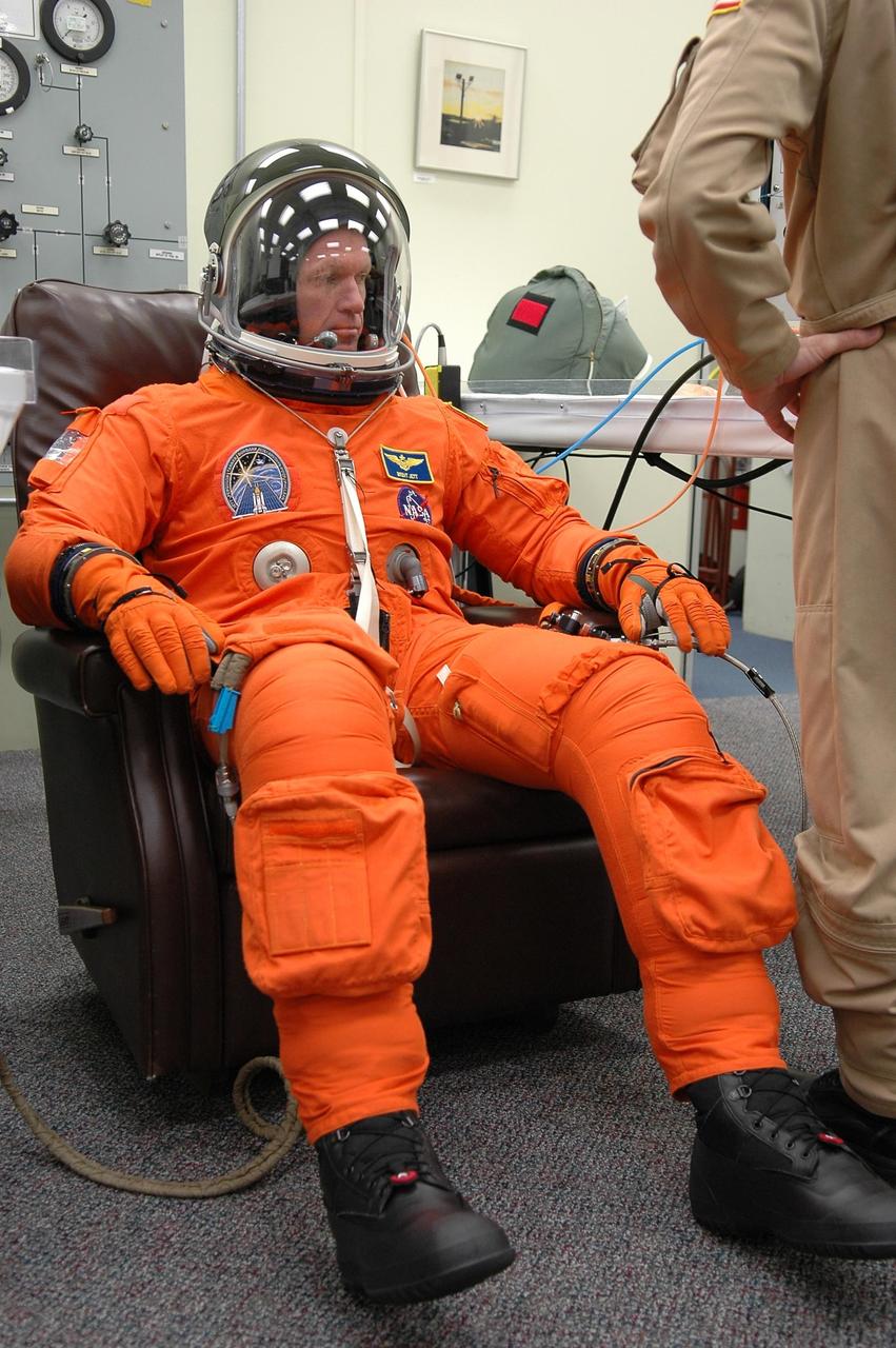 KENNEDY SPACE CENTER, FLA. - In the Operations and Checkout Building at NASA Kennedy Space Center, STS-115 Mission Commander Brent Jett finishes suiting up for another attempt at liftoff. The launch attempt on Sept. 8 was scrubbed due to an issue with a fuel cut-off sensor system inside the external fuel tank. This is one of several systems that protect the shuttle's main engines by triggering their shutdown if fuel runs unexpectedly low.  During the STS-115 mission, Atlantis' astronauts will deliver and install the 17.5-ton, bus-sized P3/P4 integrated truss segment on the station. The girder-like truss includes a set of giant solar arrays, batteries and associated electronics and will provide one-fourth of the total power-generation capability for the completed station. This mission is the 116th space shuttle flight, the 27th flight for orbiter Atlantis, and the 19th U.S. flight to the ISS. STS-115 is scheduled to last 11 days with a planned landing at KSC.  Photo credit: NASA/Kim Shiflett